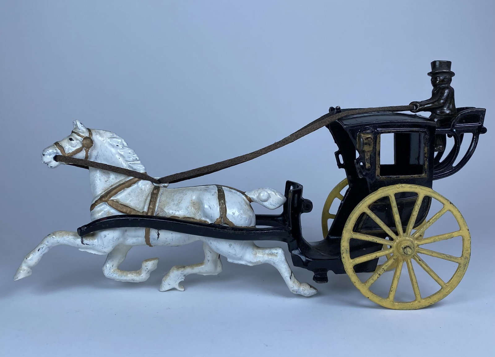 KENTON HANSOM CAB HORSE DRAWN TOY: KENTON HANSOM CAB HORSE DRAWN TOY. APPEARS TO BE TURN OF THE CENTURY VERSION WITH JAPANNED DRIVER AND ENHANCED WHITE PAINT. REPAINTED WHEELS. FRONT WHEEL ON HORSE MISSING.