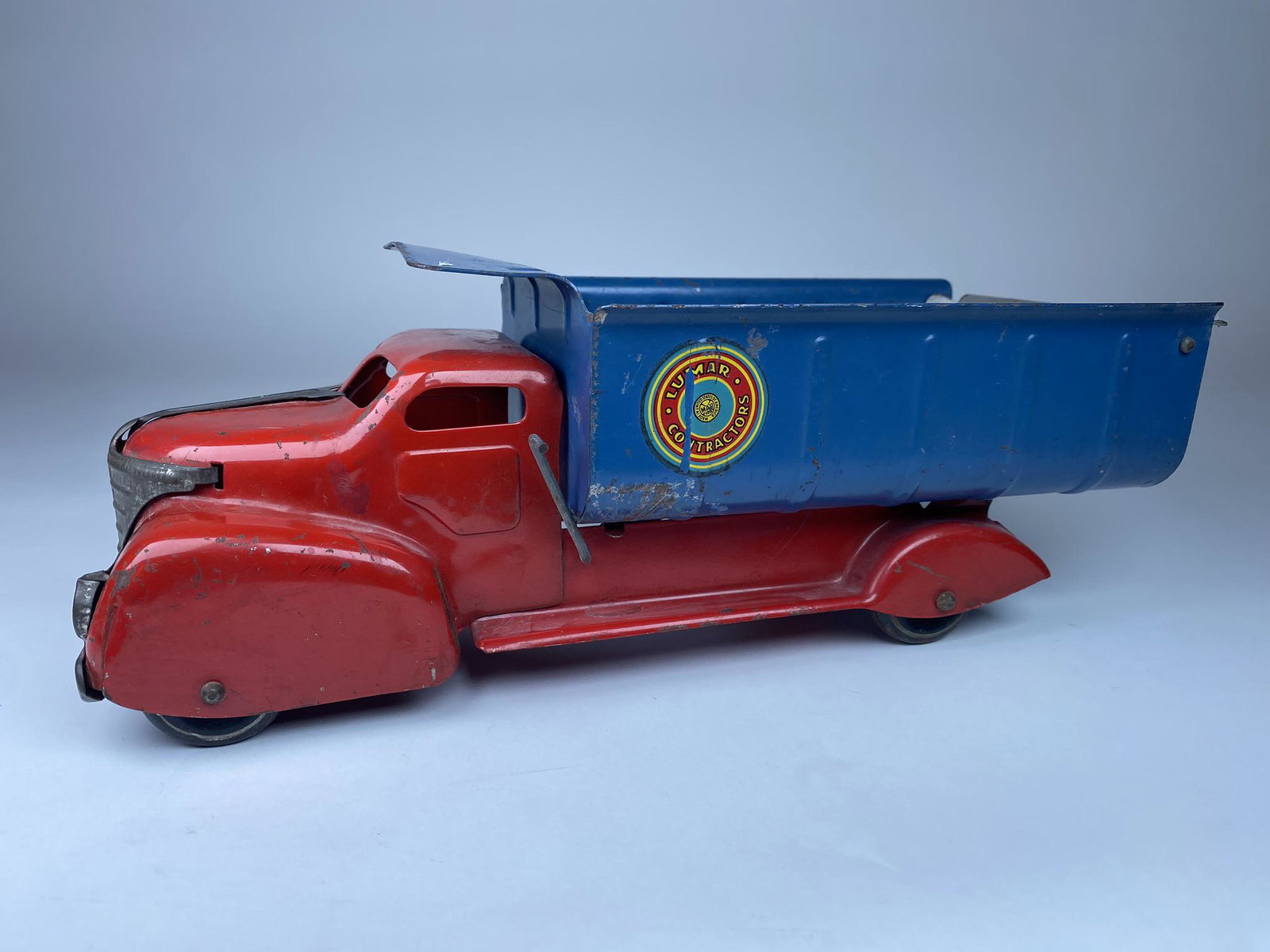 MARX LUMAR CONTRACTORS DUMP TRUCK: NICE ORIGINAL LUMAR CONTRACTORS DUMP TRUCK WITH ORIGINAL STICKER AND TAILGATE. ORIGINAL GRILL. WORKING WITH ORIGINAL TIN WHEELS. 13.5"