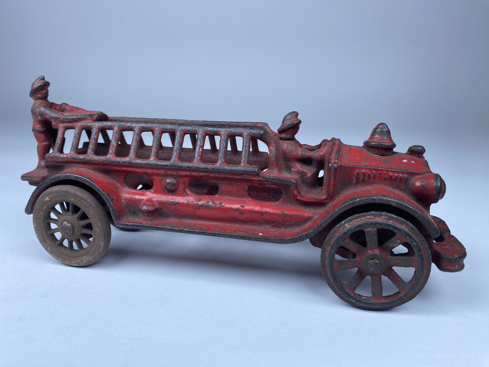 AC WILLIAMS FIRE LADDER TRUCK: RED ORIGINAL PAINT AC WILIAMS LADDER TRUCK WITH TWO CAST IN DRIVERS. REPLACED FRONT WHEELS. 7.5" L