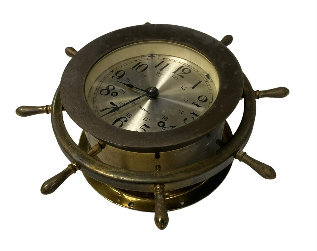 SETH THOMAS SHIP CLOCK: WITH KEY. BRASS WITH SHIP WHEEL MOTIF. 9" DIA.