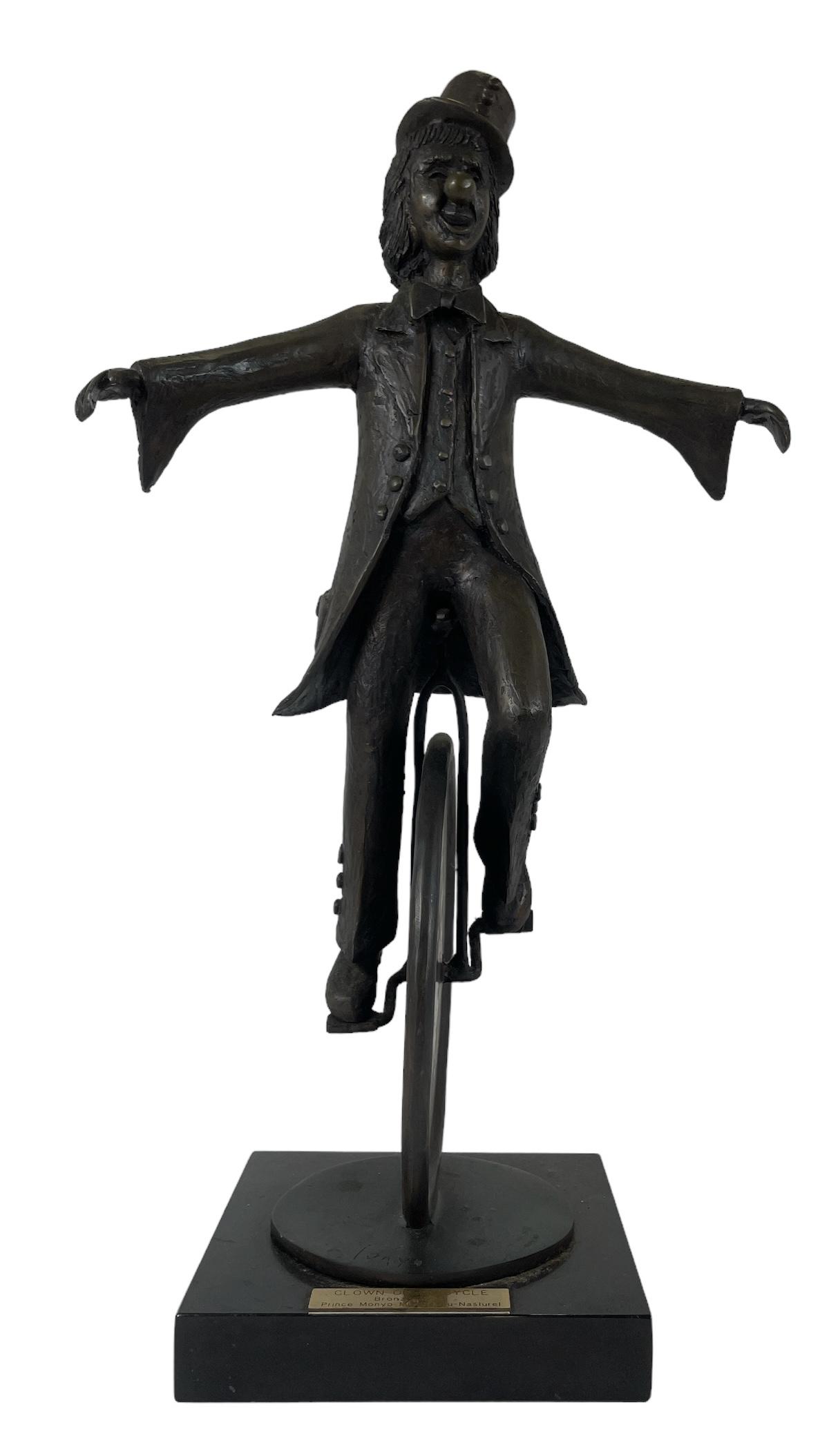 PRINCE MONYO MIHAELESCU-NASTUREL BRONZE: BRONZE SCULPTURE OF A CLOWN RIDING A UNICYCLE, MOUNTED ON A BLACK STONE BASE. 23.5"