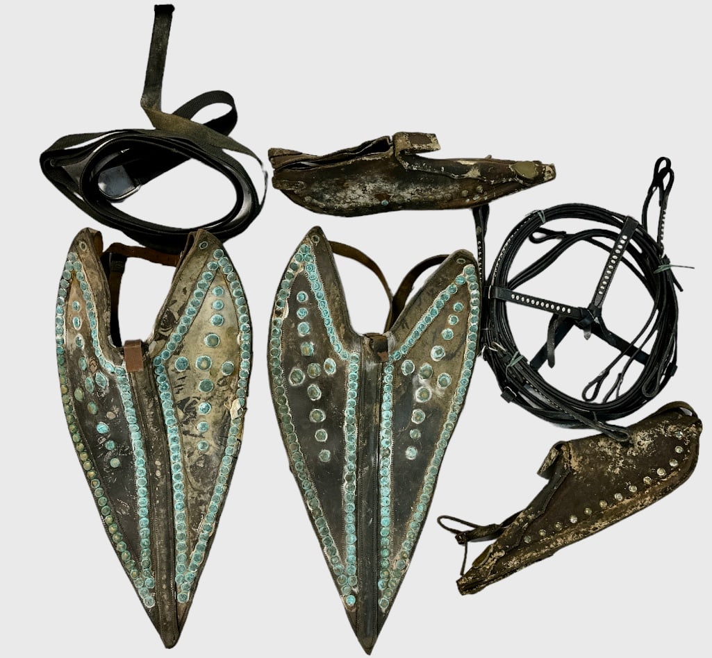 CIRCUS ELEPHANT HEAD DRESSES: GROUPING OF ELEPHANT HEAD-GEAR, LEATHER WITH PATINATED BRASS STUDS. UNKNOWN.