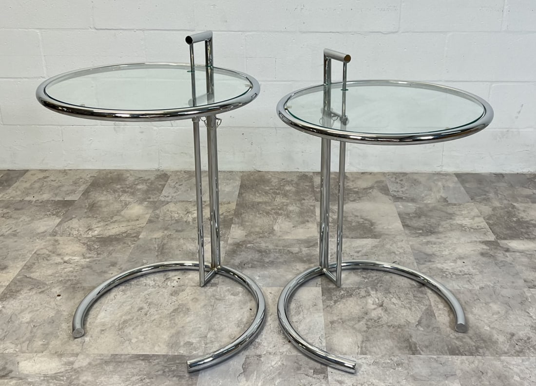 AFTER EILEEN GRAY SIDE TABLES: PAIR OF ADJUSTING SIDE TABLES, CHROME STRUCTURE WITH GLASS. ADJUSTS FROM 21" TO 28".