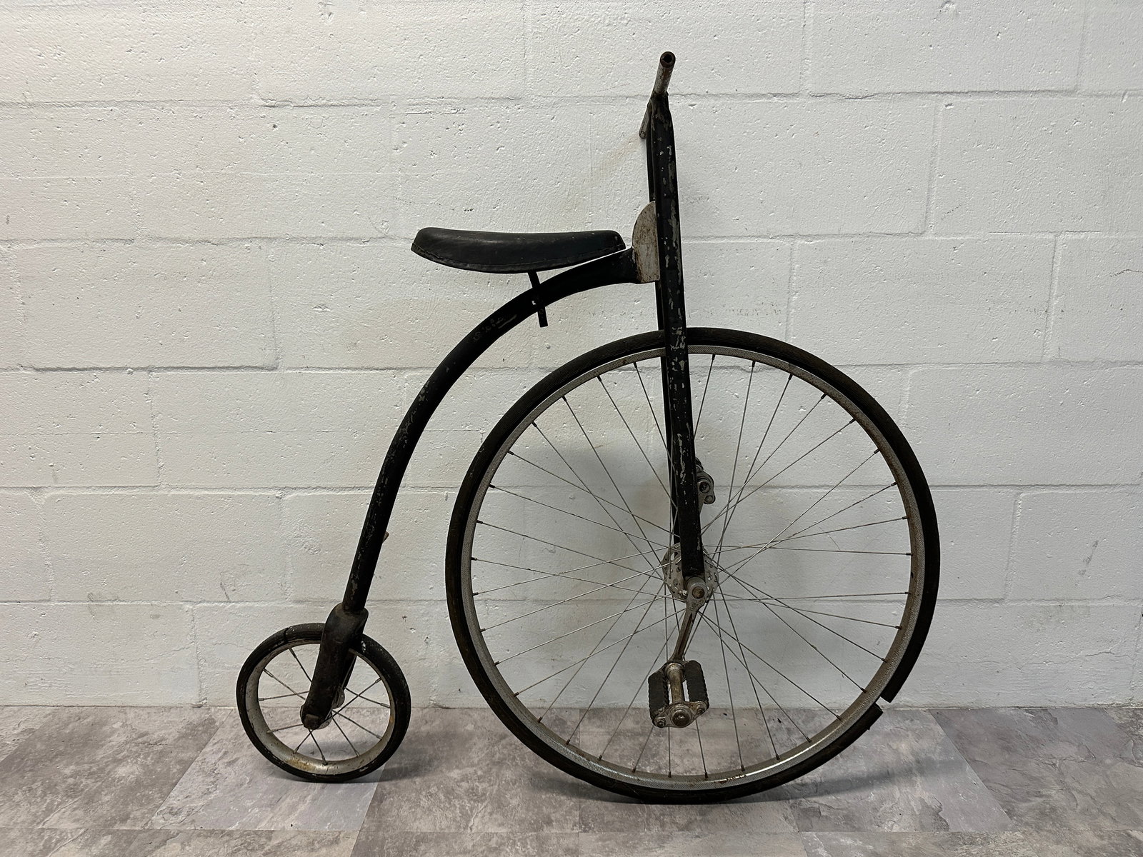 ANTIQUE HIGH WHEEL BICYCLE: ANTIQUE HIGH WHEEL BICYCLE, UNKNOWN MANUFACTURER. ORIGINAL CONDITION AS IS, FUNCTIONING AS INTENDED. INCLUDES A 1970 AUCTION INVOICE. FRONT WHEEL DIAMETER IS 26"