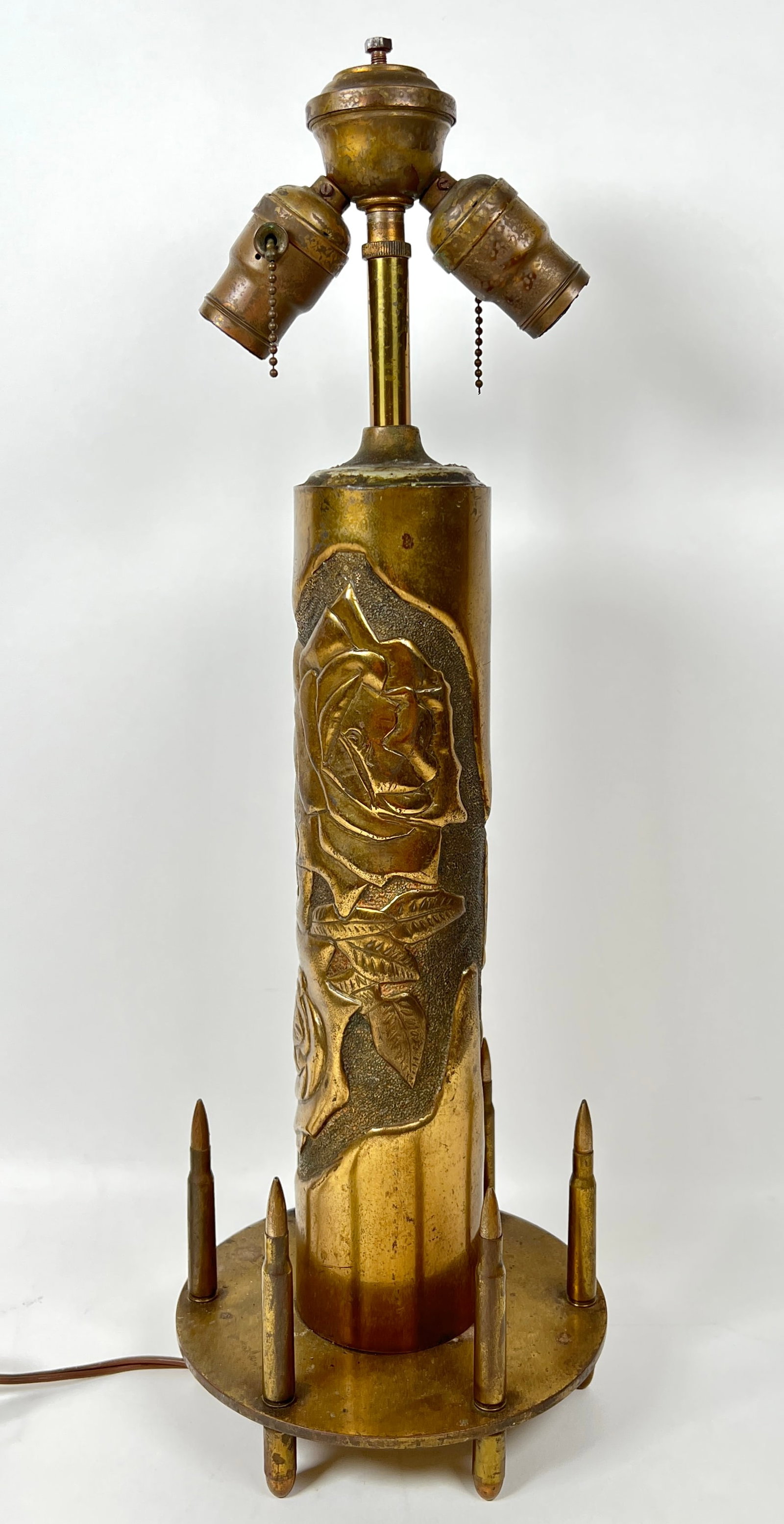 WWI MILITARY TRENCH ART LAMP: MADE FROM A HAMMERED AND POLISHED FRENCH 75MM BRASS ARTILLERY SHELL WITH BULLET AND CARTRIDGES USED AS A BASE. HAS BEEN REWIRED AND IS COMPLETE AND OTHERWISE UNALTERED. THE SHADE WOULD HAVE BEEN A U.S