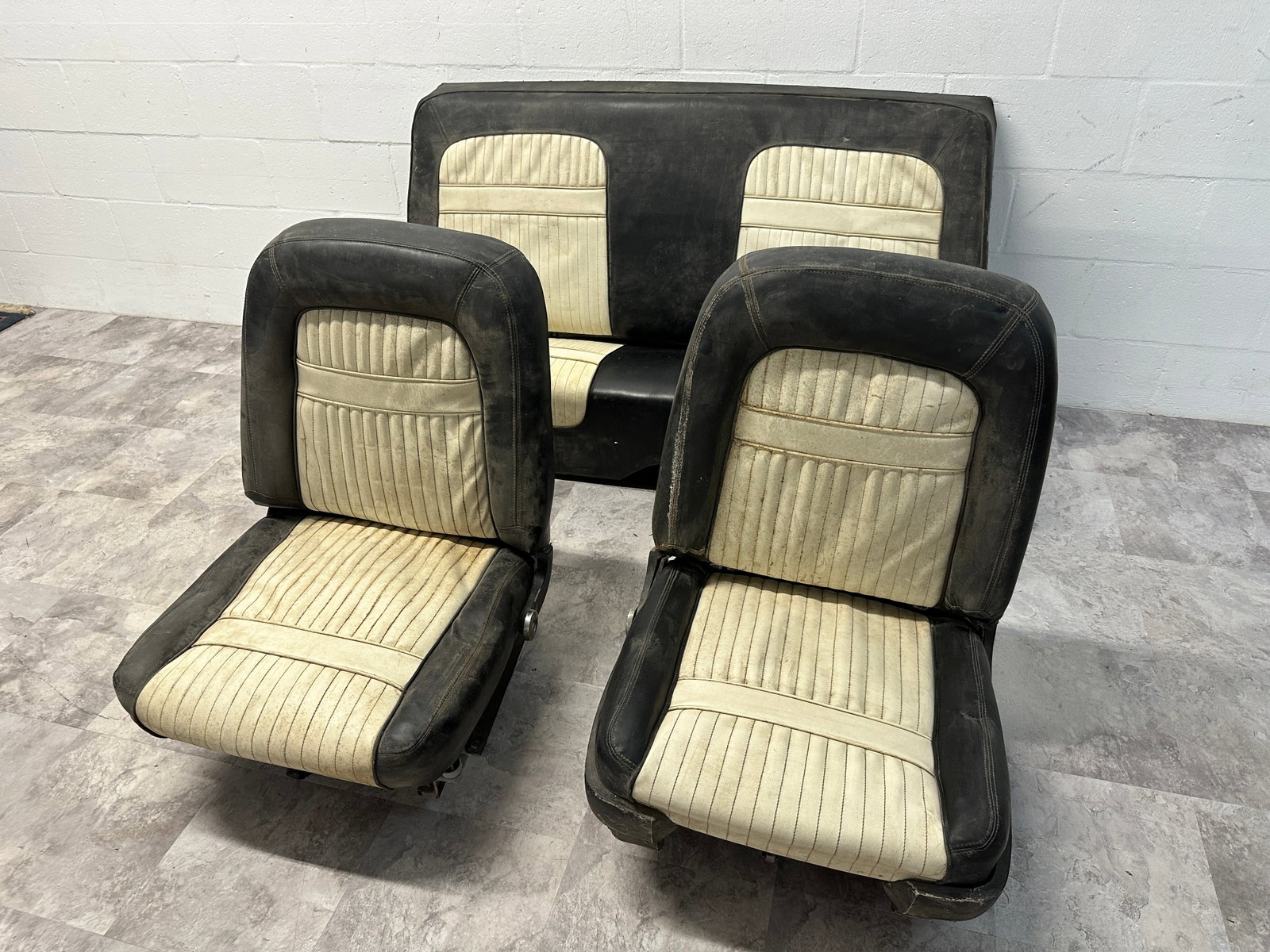 1950'S-60'S U.S. AUTO INTERIOR: INCLUDES PAIR OF BUCKET SEATS AND REAR BENCH IN BLACK AND WHITE VINYL. WEAR AS SHOWN.