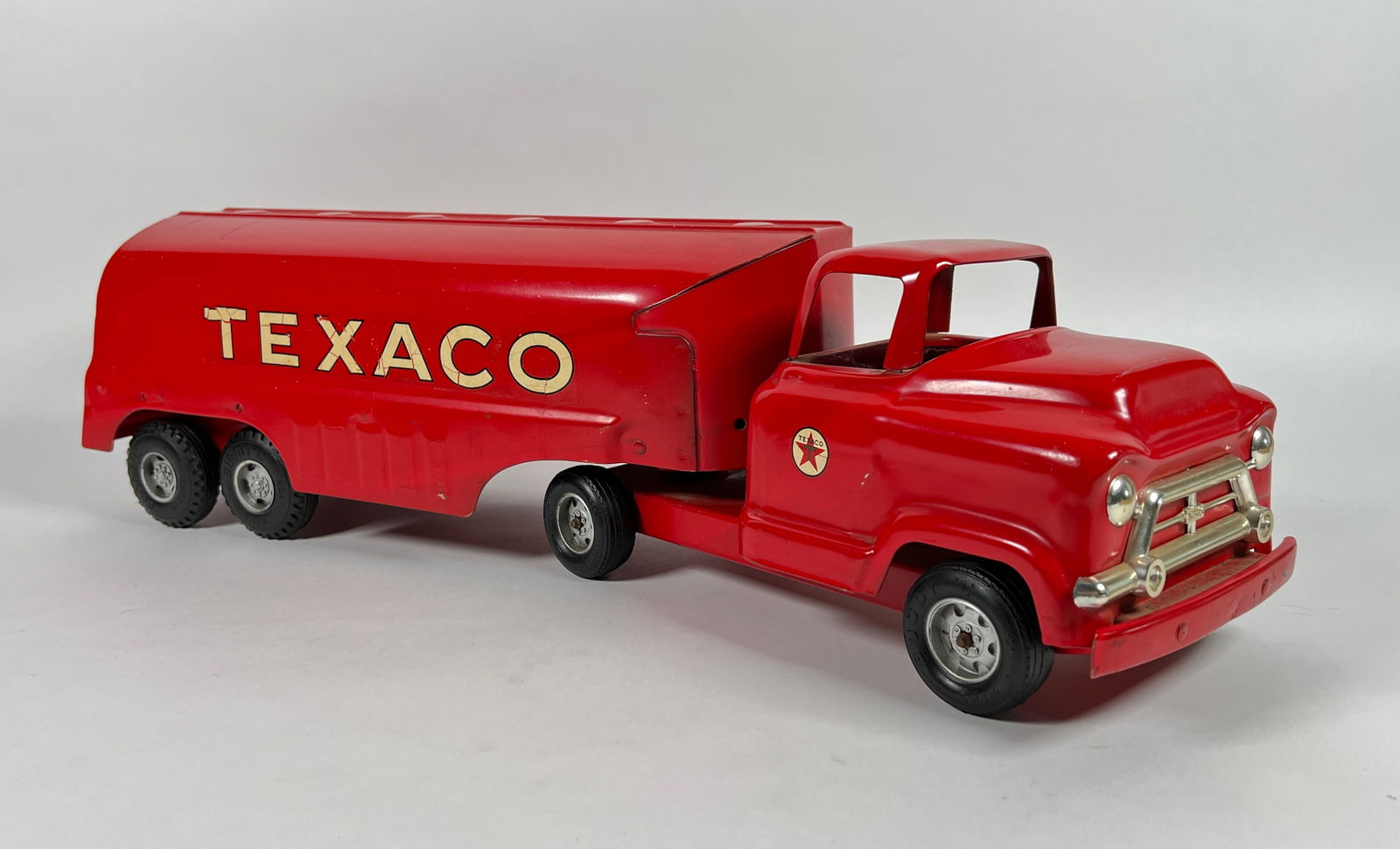BUDDY L TEXACO TANKER TRUCK: PRESSED STEEL, LIGHT PLAY WEAR, SCATTERED WHITE PAINT SPECS ON TOP SIDE. MISSING A PORTION OF THE LEFT FRONT GRILL BAR. 24"L