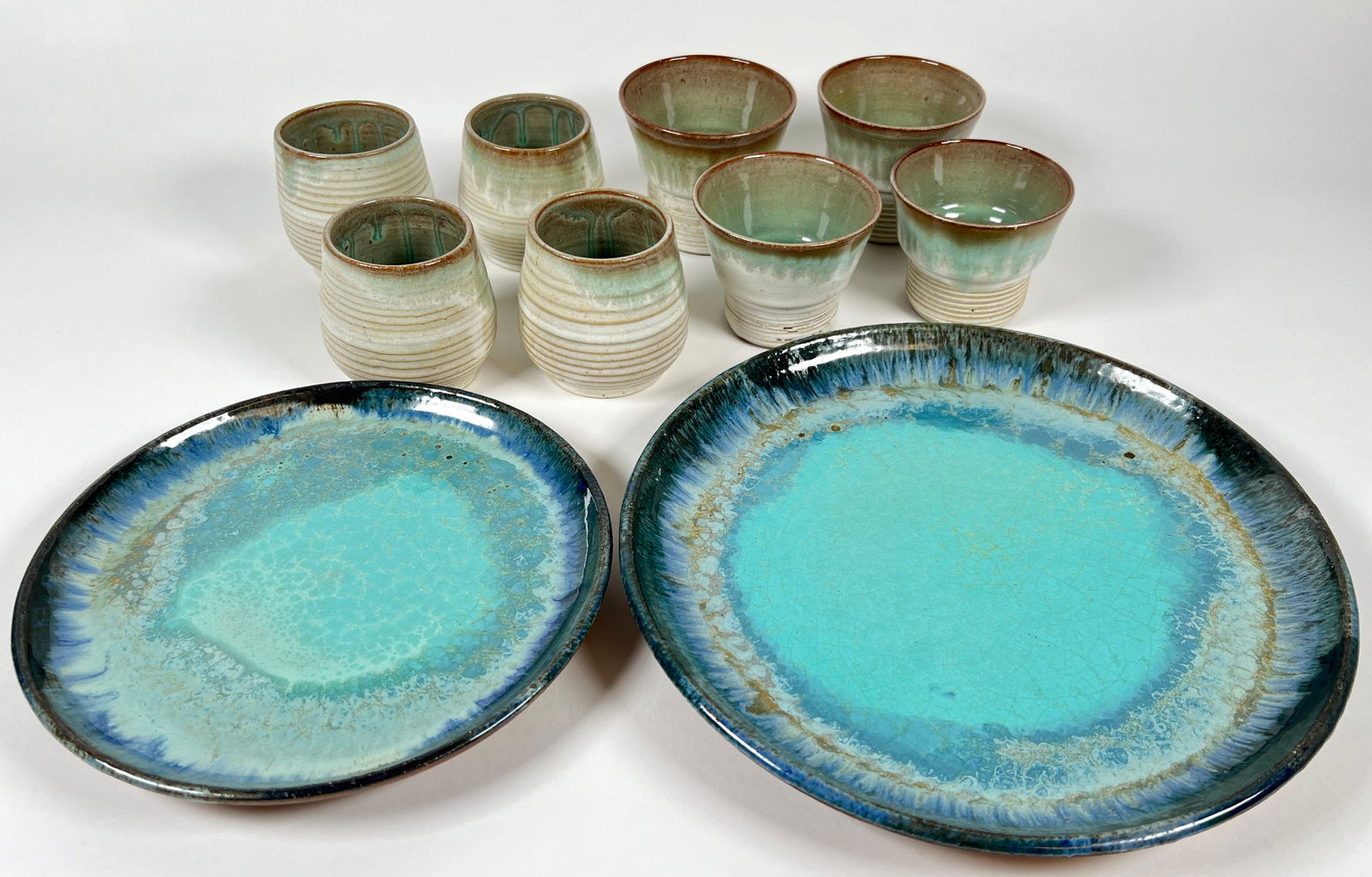MERRITT ISLAND POTTERY GROUPING: PAIR OF POTTERY PLATES AND 8 GOBLETS. PLATES 8" AND 10", GOBLETS 3"