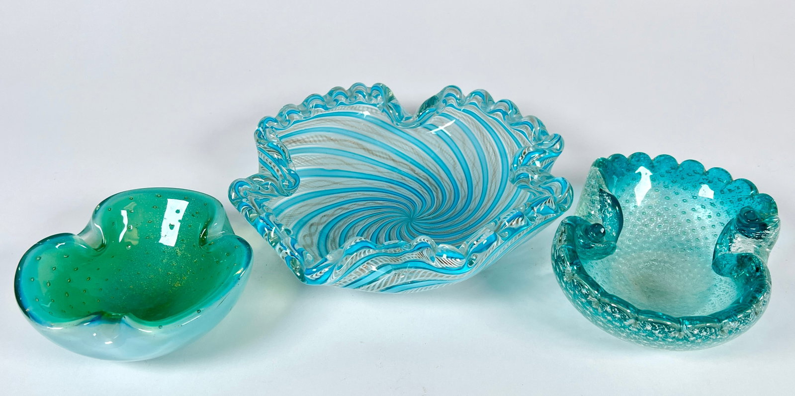 TRIO OF MURANO ART GLASS ASHTRAYS: STUNNING BLUE SWIRLED LATTICINO WITH GOLD AVENTURINE 9", AQUA SILVER AVENTURINE WITH CONTROLLED BUBBLE, 6", TEAL WITH GOLD AVENTURINE AND CONTROLLED BUBBLE 5"