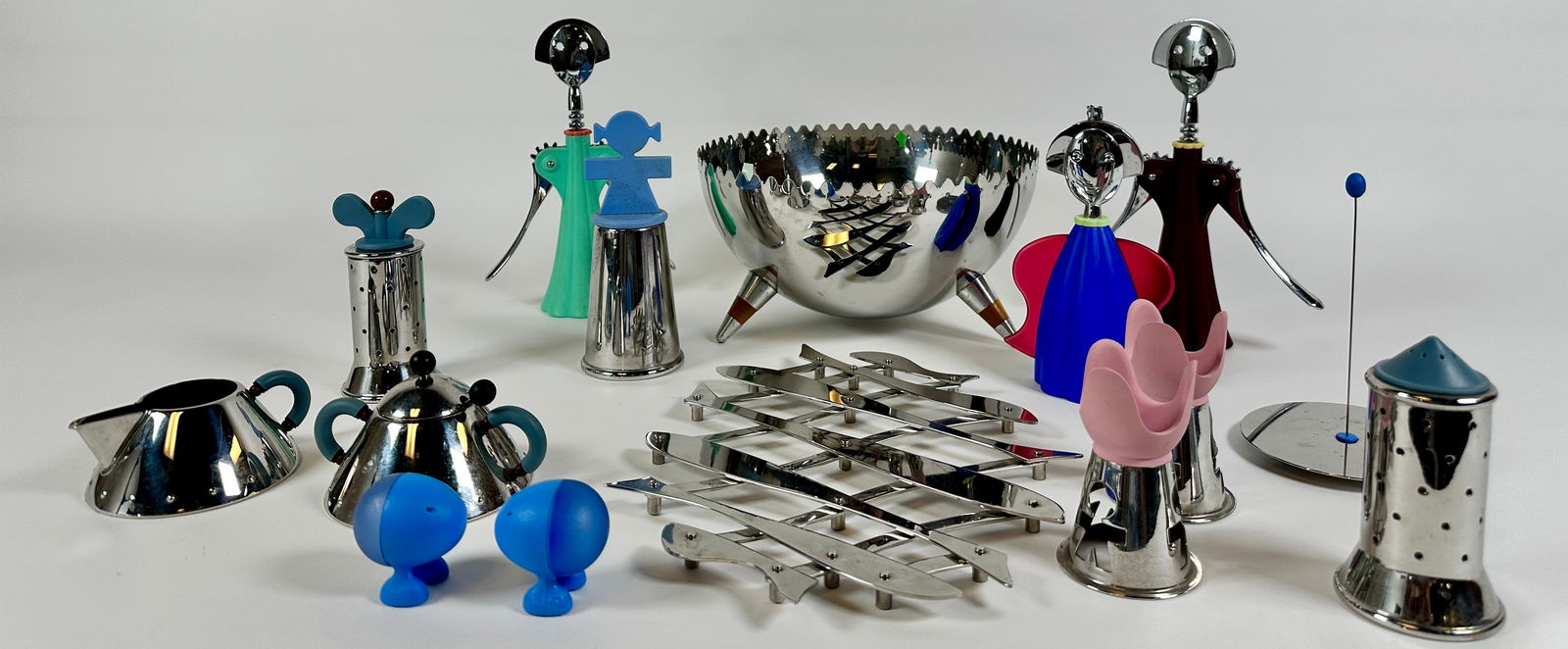 ALESSI TABLE SERVICE COLLECTION: INCLUDES SERVING BOWL, WINE OPENERS, SALT AND PEPPERS, LIGHTER, SUGAR CREAMER, PEPPER MILLS, EGG CUPS, EXPANDING TRIVET. ALL GENTLY USED.