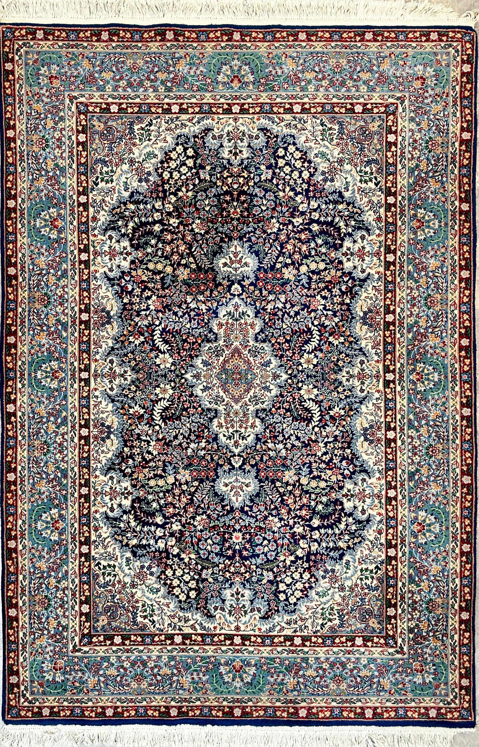 INDO-PERSIAN AREA CARPET: CLEAN WITH BRILLIANT FLORAL DESIGNS IN RED AND BLUE TONES. 5'6"X8'2"
