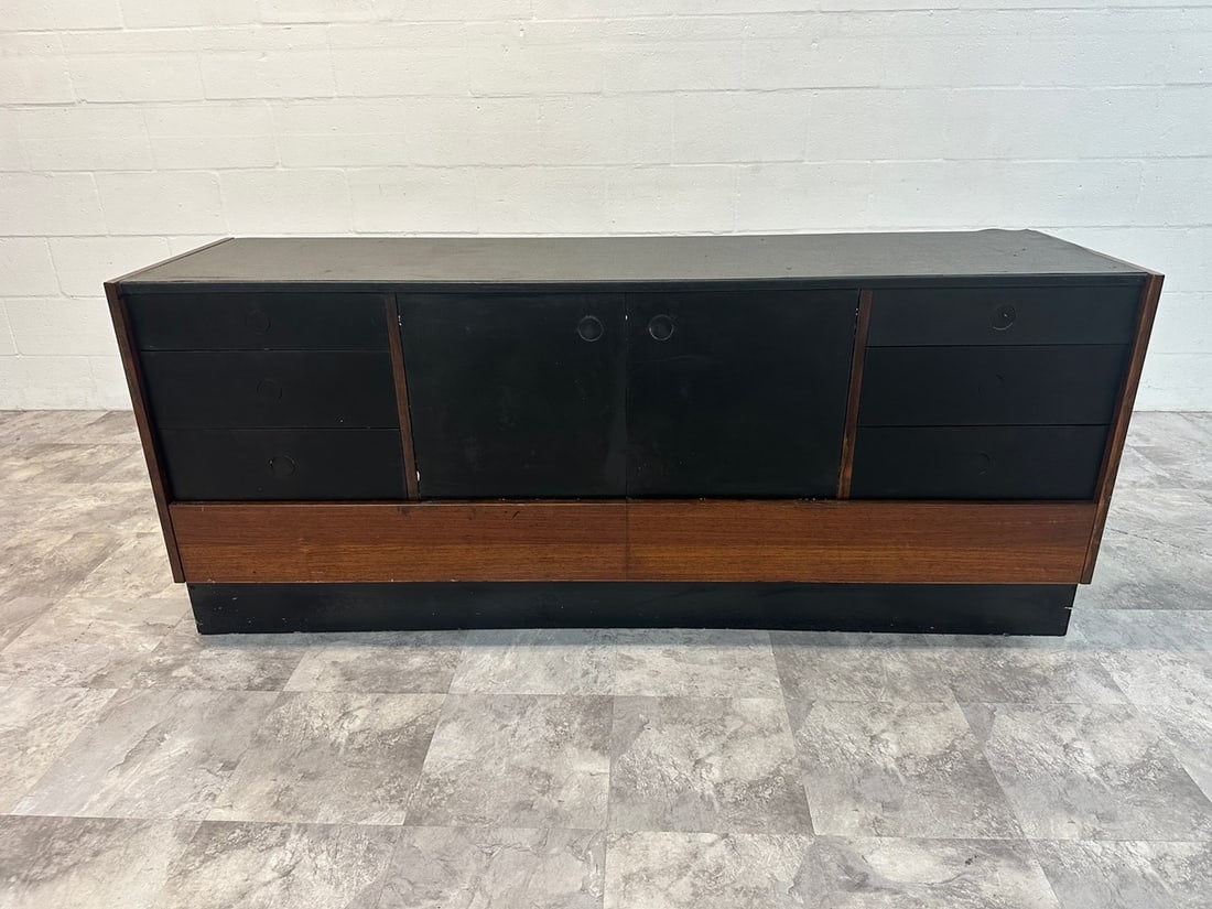 DYRLUND ROSEWOOD LONG DRESSER: ROSEWOOD AND EBONY, LABELED. APPLIED FOAM TOP AND EBONY DRAWER FRONTS WITH ROSEWOOD STRUCTURE. LABELED. MISSING A SMALL PIECE OF VENEER ON PLINTH BASE SIDE. 68”W, 18”D, 28”H.