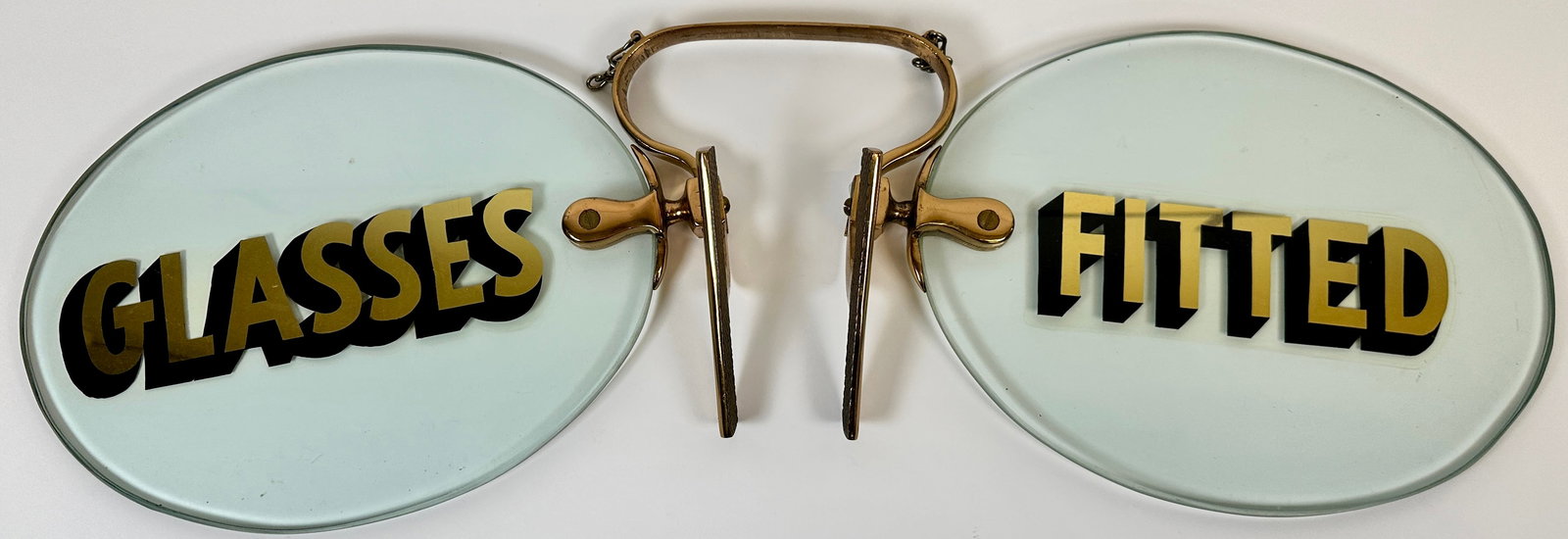 LARGE OPTOMETRIST - GLASSES FITTED TRADE SIGN: OVERSIZED TRADE SIGN FIXTURE IN EYEGLASS FORM, GILT LETTERLING, GLASS SPECTACLES WITH HEAVY BRASS FITTING. 28"X9"