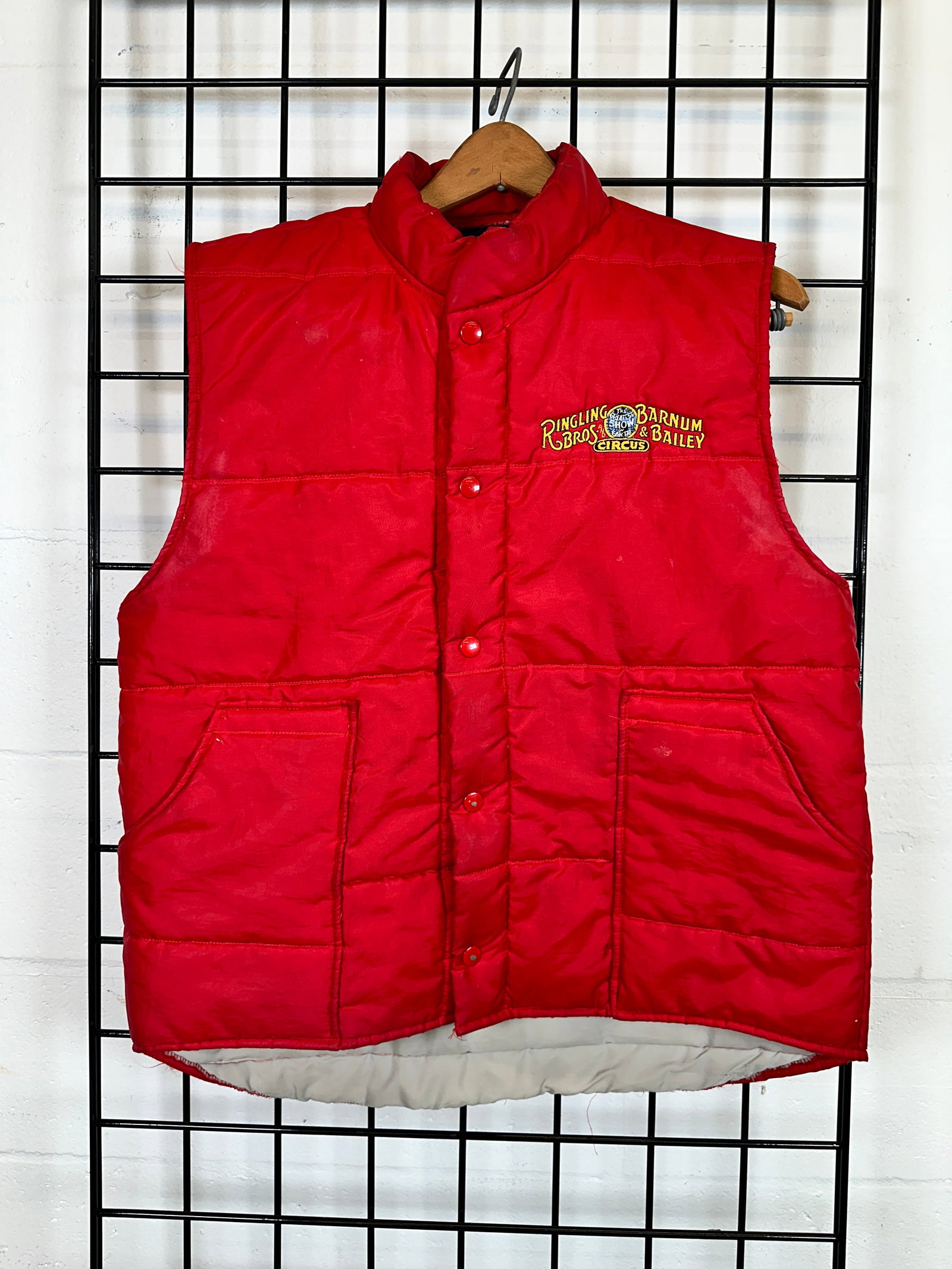 GUNTHER GEBEL WILLIAMS ELEPHANT WALK VEST: RED PUFFER-STYLE VEST AS WORN BY GGW AS WORN ON ELEPHANT WALKS FROM THE TRAIN TO THE VENUE. PURPORTEDLY GUNTHER WAS THE ONLY HANDLER IN RED DURING SUCH WALKS. GGW COLLECTION. GUNTHER GEBEL WILLIAMS (G