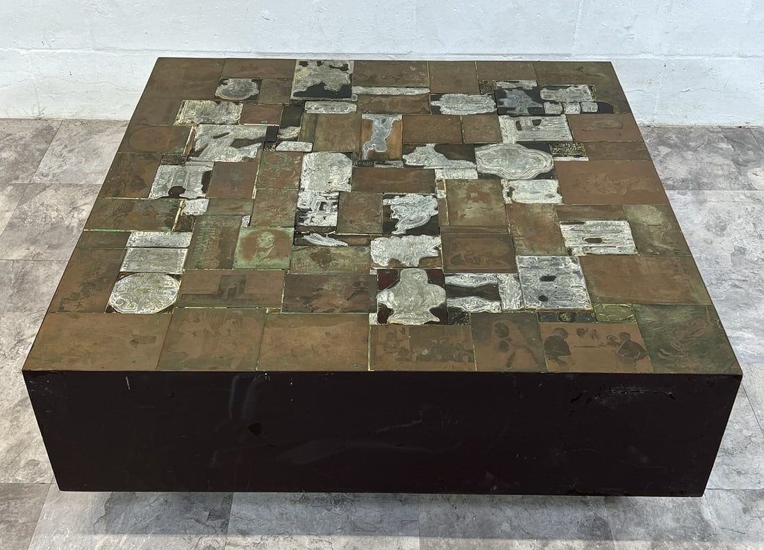 MANNER OF PAUL EVANS COFFEE TABLE: APPLIED METAL PRINTER PLATES TO PLINTH BASE COFFEE TABLE. PRINTER PLATE SUBJECTS INCLUDE HISTORICAL MOTIF INCLUDING U2 SPY PLANE, MOON LANDING AND OTHERS. A GREAT CONVERSATION TABLE. 38"X38"X14". UNSI