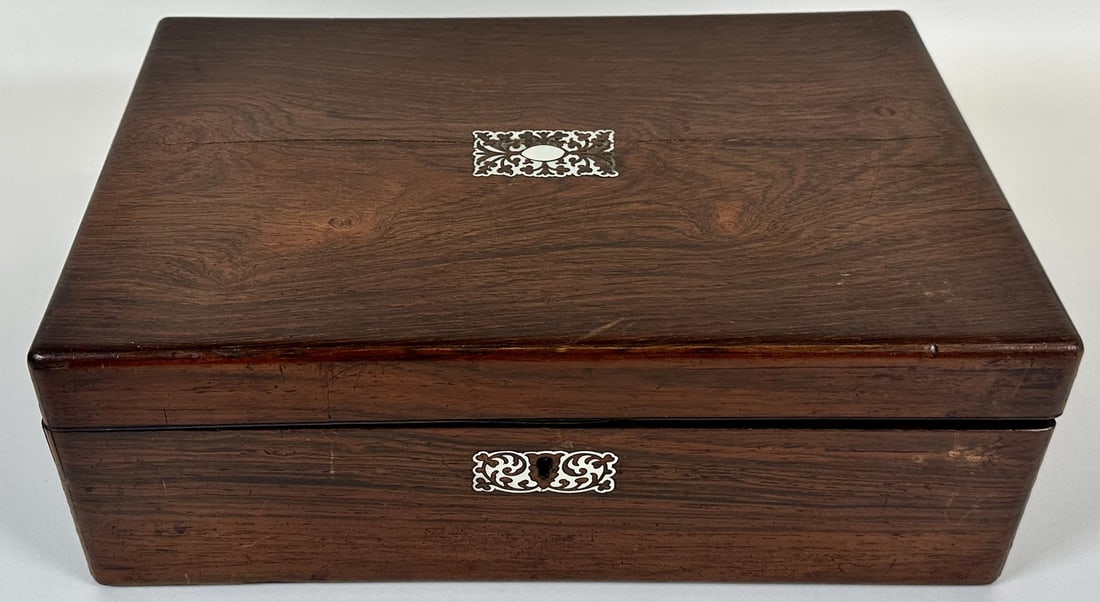 ANTIQUE TRAVEL WRITING DESK: MOTHER OF PEARL INLAID DESIGN, LEATHER WRITING TOP. SOME TWO AREAS OF CASE SPLITTING. WHEN CLOSED 14"X9"X5"