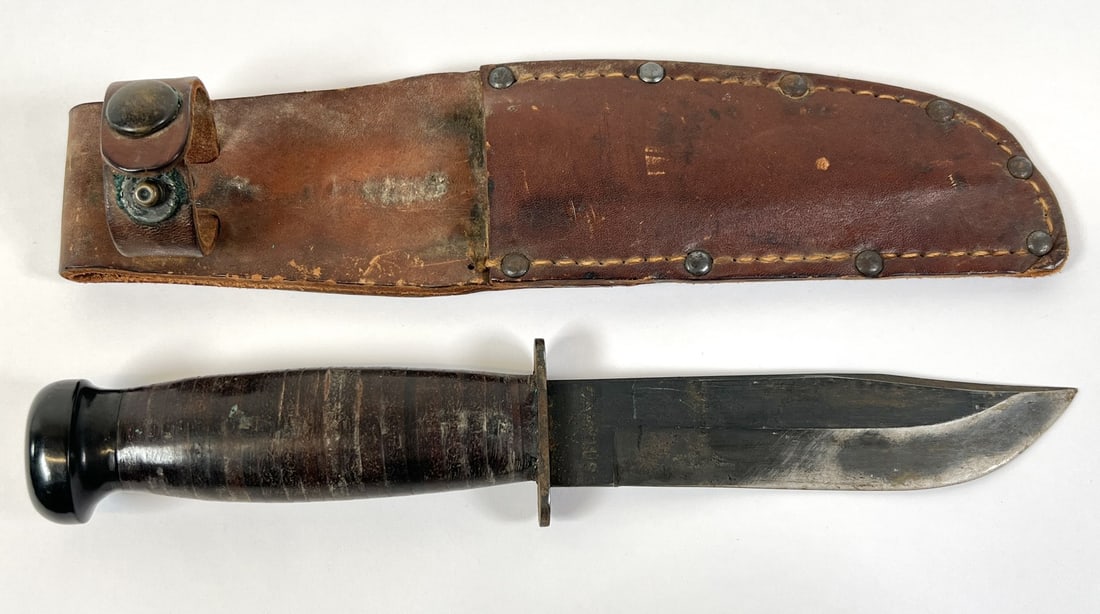 CAMILLUS U.S.N. FIGHTING KNIFE: LEATHER WASHER HANDLE, LEATHER SHEATH. OVERALL 9.5"