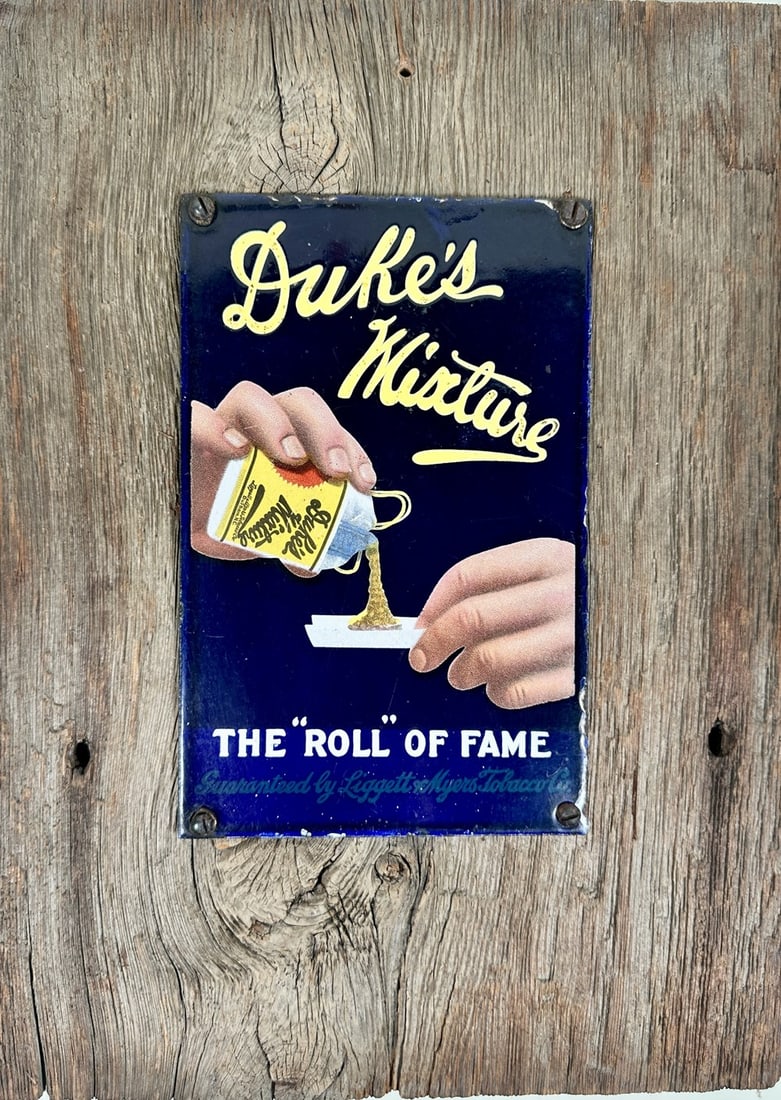 DUKE'S MIXTURE TOBACCO SSP SIGN: DUKE'S MIXTURE - THE ROLL OF FAME - GUARANTEED BY THE LIGGETT & MYERS TOBACCO COMPANY. SINGLE SIDED PORCELAIN SIGN MOUNTED ON BARN BOARD PANEL. EDGE WEAR. SIGN IS 5.25"X8". MOUNTING IS 10"X14"