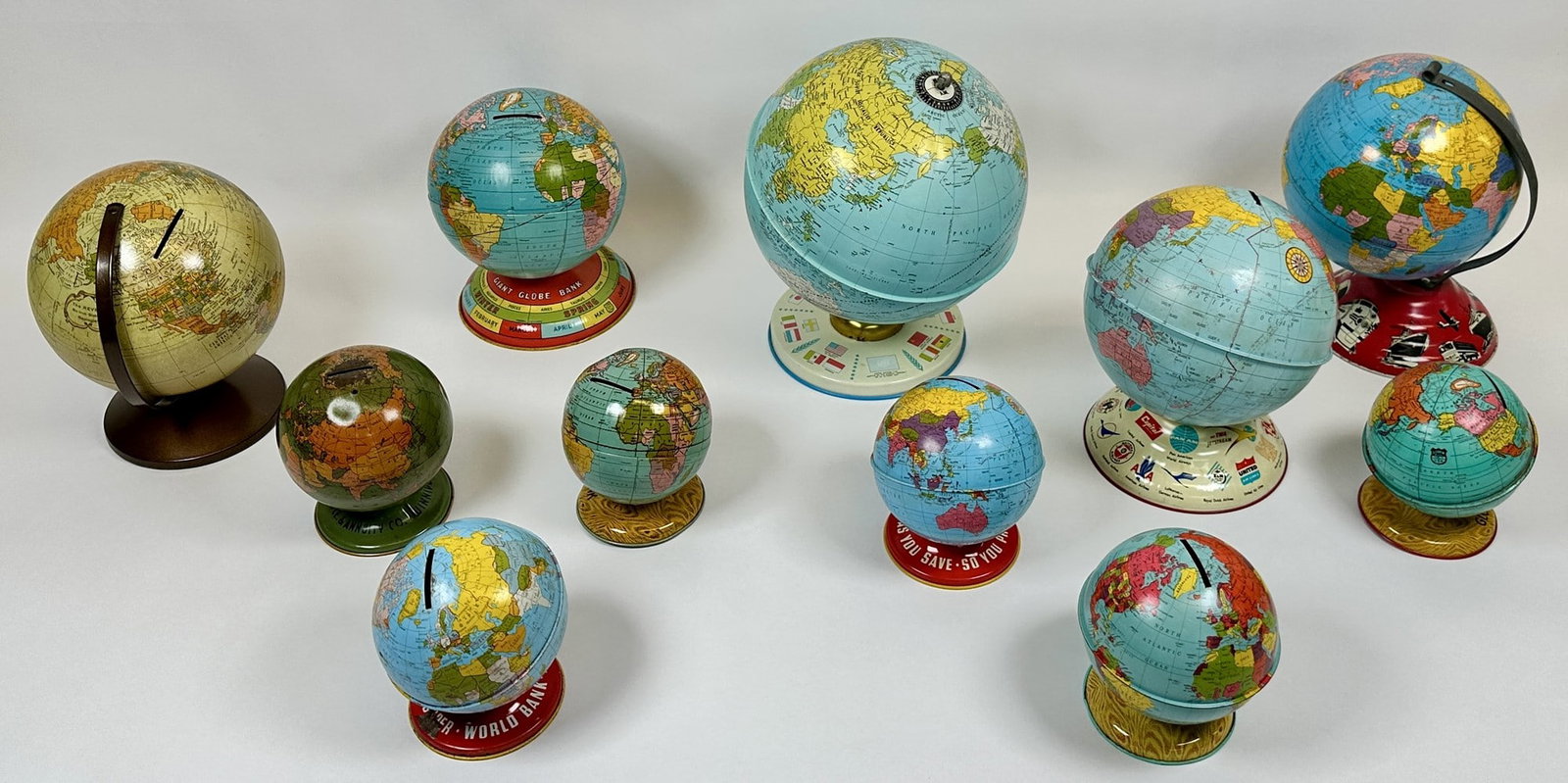 COLLECTION OF TIN LITHO GLOBES: COMBINATION OF BANKS AND GLOBES. LARGEST IS 9.5"H