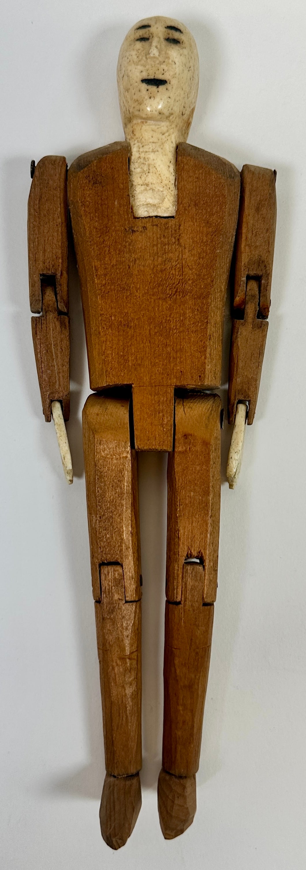 Eskimo Jig Doll: Articulated joints, wooden body with organic bone carved head and hands. 9.5"