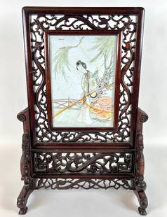 CHINESE FAMILLE ROSE PORCELAIN TABLE SCREEN: DEPICTION OF WOMAN IN GARDEN, CARVED, RETICULATED FRAME. CRACKS/REPAIRS TO TILE. 20"H. REQUIRES THIRD PARTY SHIPPING/TRANSPORATION.