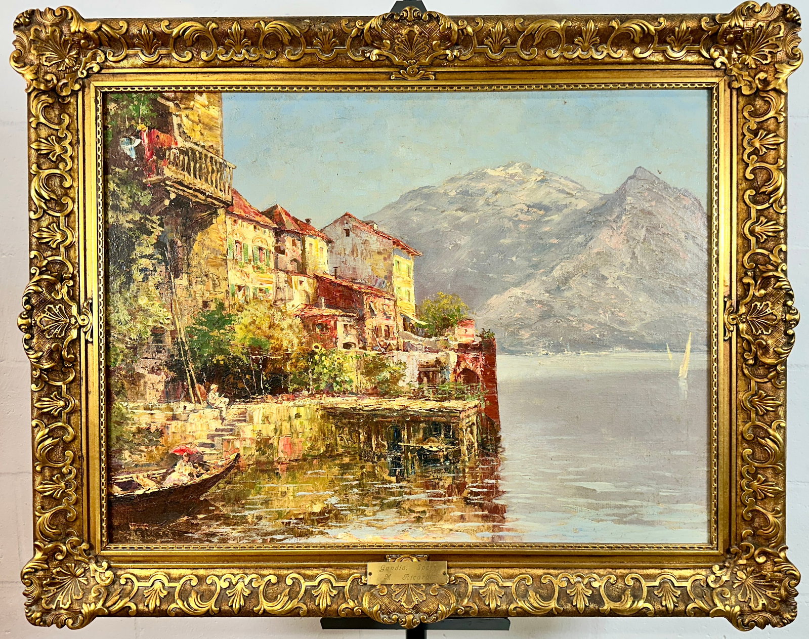 M. RICARDO LANDSCAPE PAINTING: M. RICARDO OIL ON CANVAS PAINTING, LAKE AND MOUNTAINSCAPE PAINTING. GILT GESSO FRAME WITH MINOR AREAS OF LOSS. PLAQUE MOUNTED. OVERALL 31"X39". REQUIRES THIRD PARTY SHIPPING.