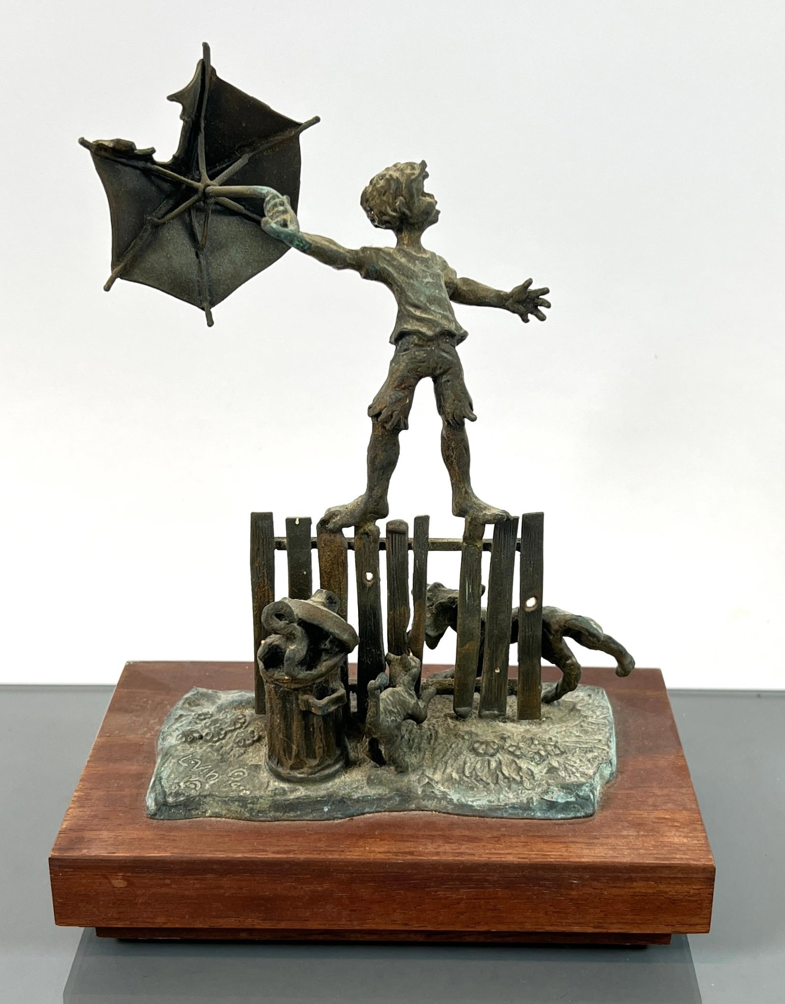 LEVIN BRONZE SCULPTURE: SIGNED LEVIN, 1970. BOY ON FENCE WITH UMBRELLA WITH DOG AND CAT BENEATH IN A QUARREL. SIGNED. 8.5"H.