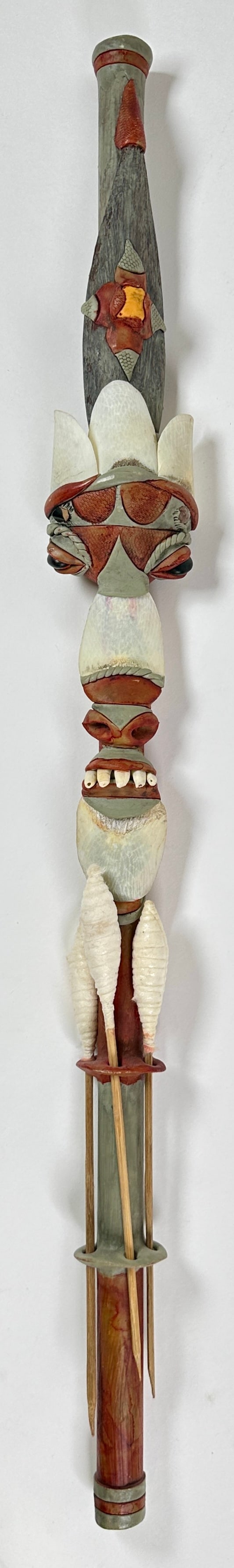 BRAZILIAN FIGURAL BLOW DART GUN: DART GUN DECORATED IN SHELLS, TEETH, ETC. 25"L