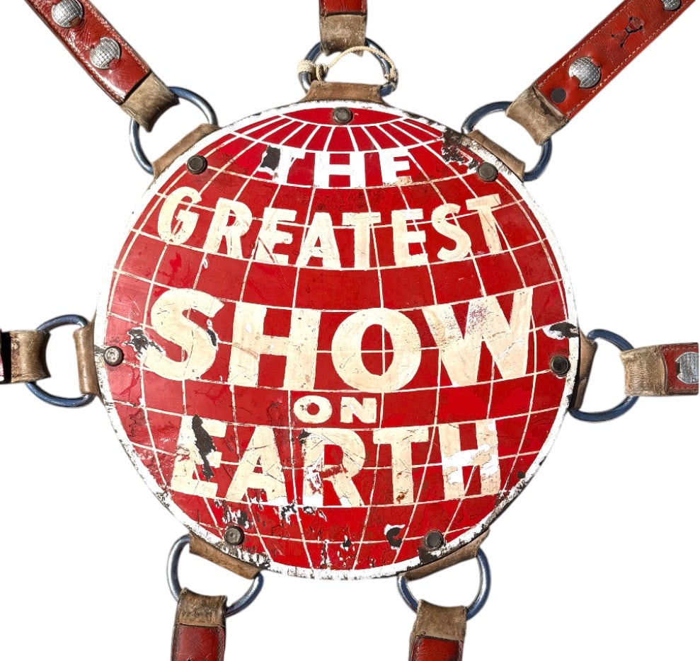 RINGLING BROS. BARNUM BAILEY CIRCUS ELEPHANT HEADDRESS: ORIGINAL ELEPHANT HEAD DRESS AS WORN BY NELLY THE ELEPHANT ON THE GREATEST SHOW ON EARTH. ROY WELLS COLLECTION. WELLS WAS A LONGTIME ANIMAL TRAINER/HANDLER. PORCELAIN MEDALLION MOUNTED ON LEATHER