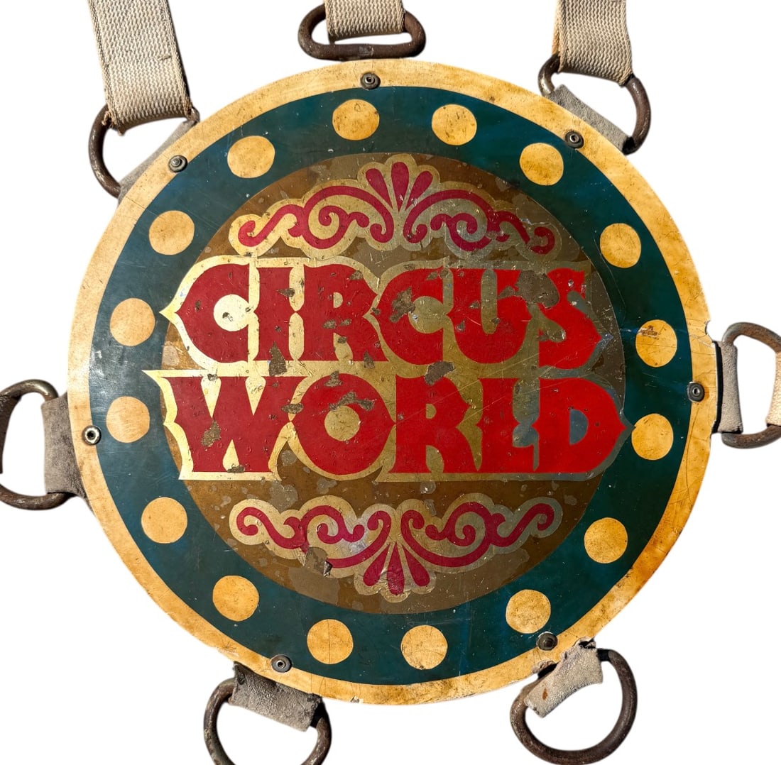 CIRCUS WORLD ELEPHANT HEADDRESS: ORIGINAL ELEPHANT HEAD DRESS AS WORN BY JOSKY THE ELEPHANT AT CIRCUS WORLD, ORLANDO, FLORIDA. ROY WELLS COLLECTION. WELLS WAS A LONGTIME ANIMAL TRAINER/HANDLER. MEDALLION MOUNTED ON LEATHER