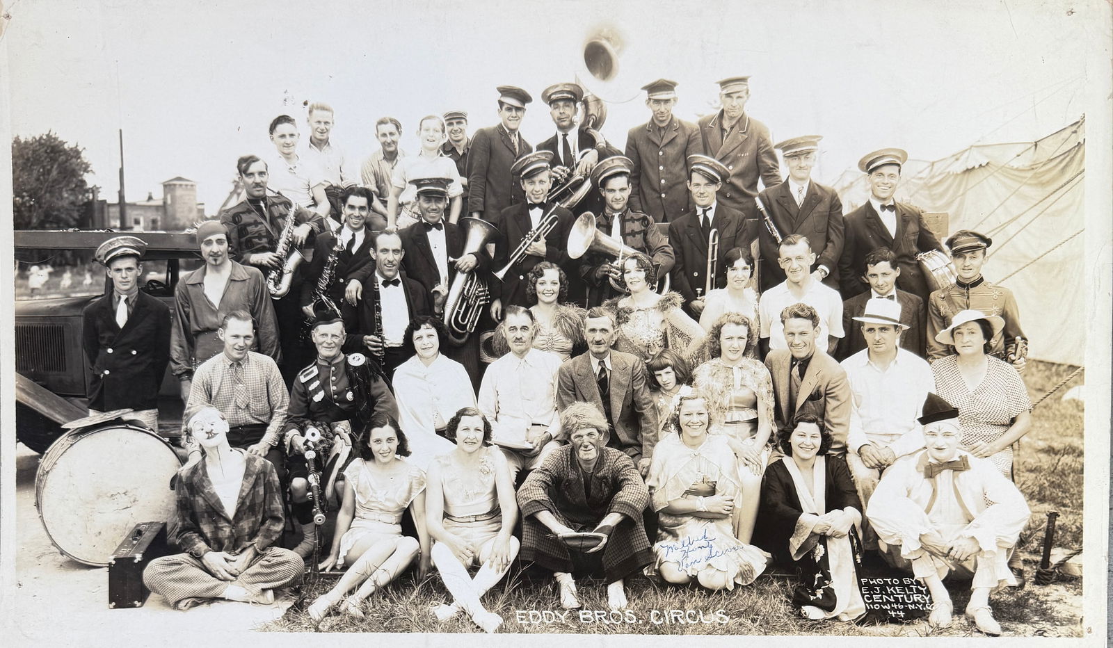 EDWARD J. KELTY CIRCUS PHOTOGRAPH, EDDY BROS.: EDWARD J. KELTY (AMERICAN, 1888-1967) PHOTOGRAPH OF THE HUNT'S EDDY BROS. CIRCUS, C.1936. PANORAMIC PHOTOGRAPH OF THE CIRCUS OWNERS, PERFORMERS AND BAND. SIGNED BY MILDRED HUNT VAN SCIVER. DOUBLE