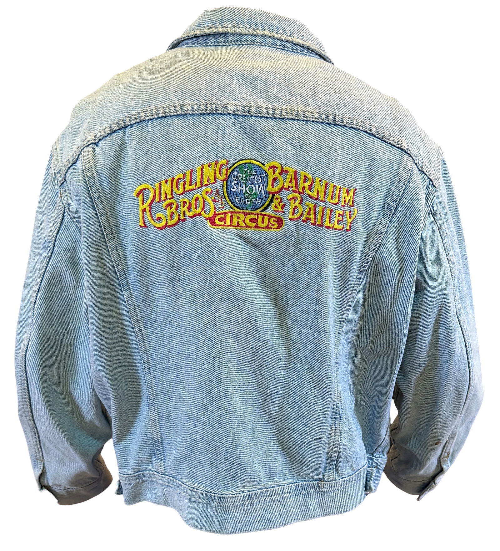 RINGLING BROS. BARNUM BAILEY CIRCUS DENIM JACKET: LEE DENIM JACKET, RBBB EMBROIDERED LOGO ON BACK, BUCKLES ON LEFT CHEST. SIZE XL. WOODCOCK COLLECTION.