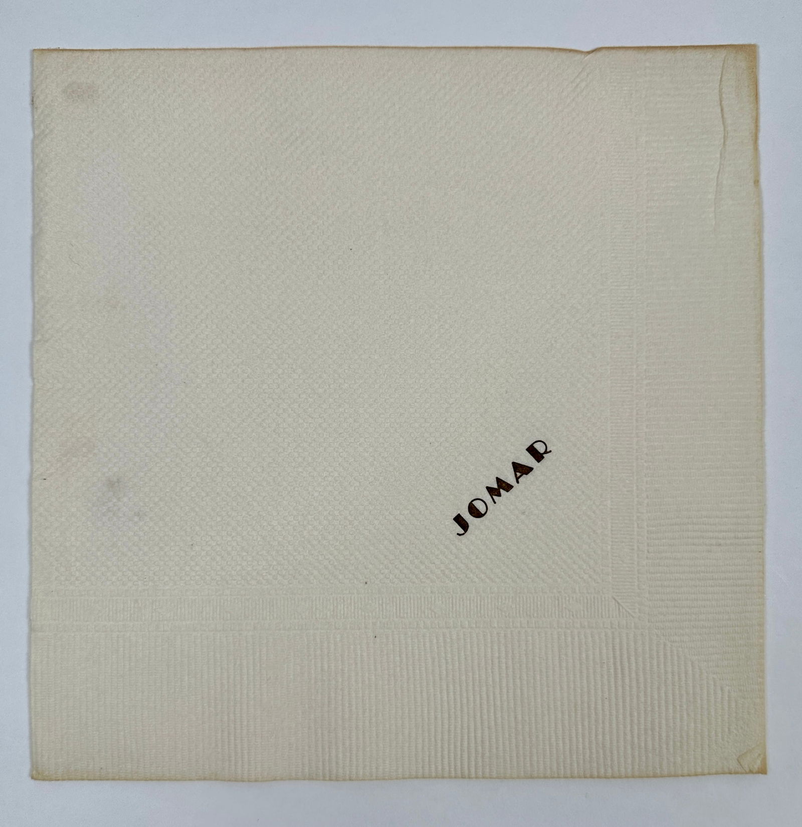 ORIGINAL JOMAR (RINGLING) TRAIN CAR NAPKIN: ORIGINAL JOMAR PAPER NAPKIN, GILT EMBOSSED. JOMAR - JOHN AND MABLE RINGLING TRAIN CAR. THE JOMAR WAS SPECIALLY BUILT FOR THE RINGLINGS IN 1917. A NOTE INCLUDED WITH THE NAPKIN: THIS NAPKIN IS FROM