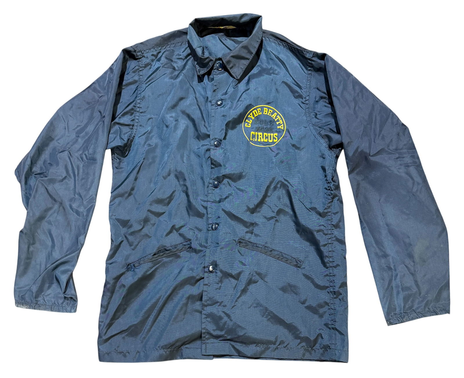 CLYDE BEATTY CIRCUS WINDBREAKER JACKET: CLYDE BEATTY WINDBREAKER JACKET. COLE BROS. CIRCUS BLACK-OUT. SIZE M. NAVY WITH YELLOW SCRIPT.