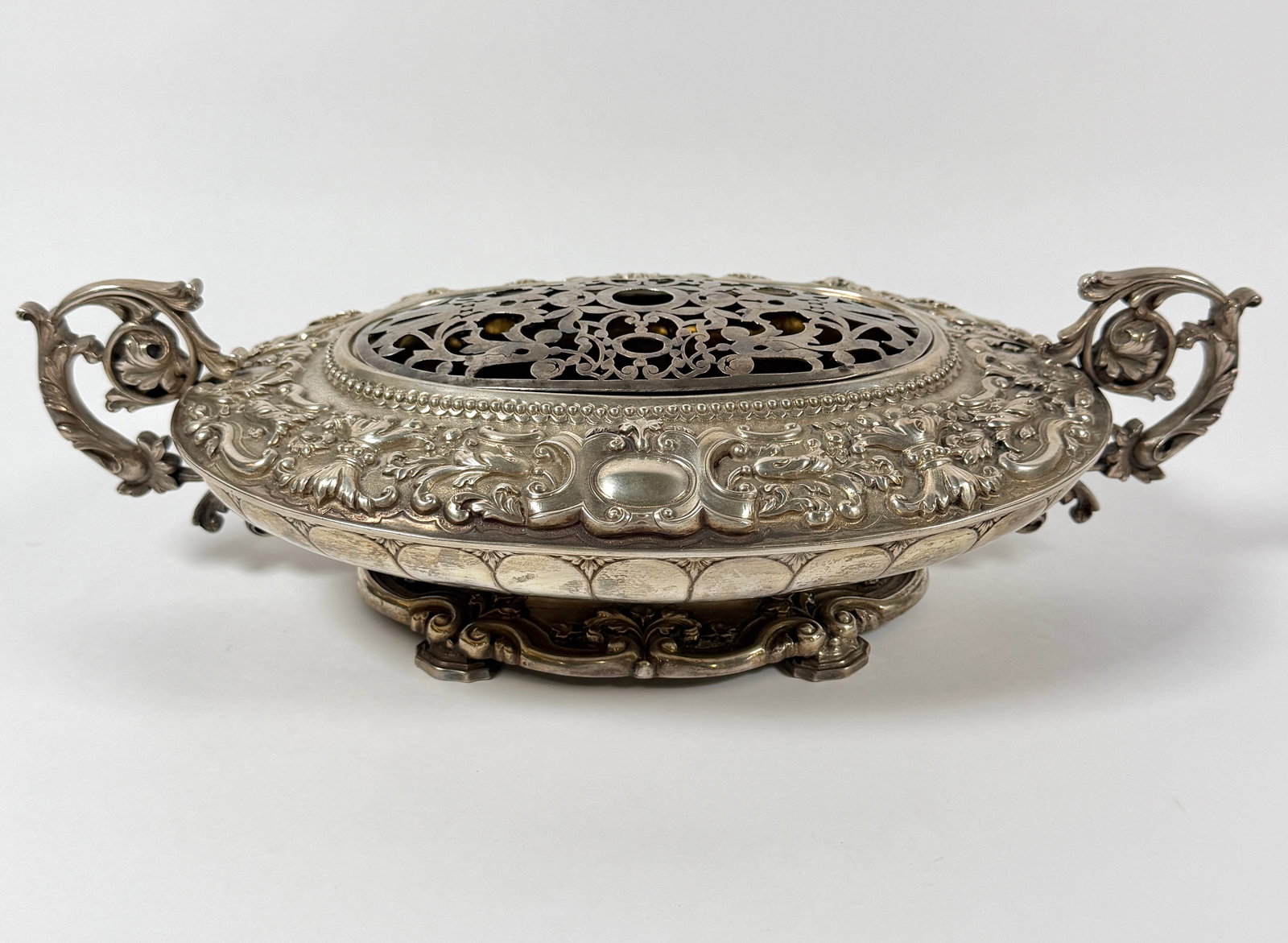 PORTUGUESE SILVER CENTERPIECE: DETAILED SILVER FOLIATE AND FLORAL CENTERPICE, SCROLLED HANDLES, MARKED .833. REMOVEABLE RETICULATED FLOWER FROG MARKED .833. 17.5"X10"X4.75"H. 2,137 GRAMS IN TOTAL WEIGHT OR 63.55 TROY OUNCES.