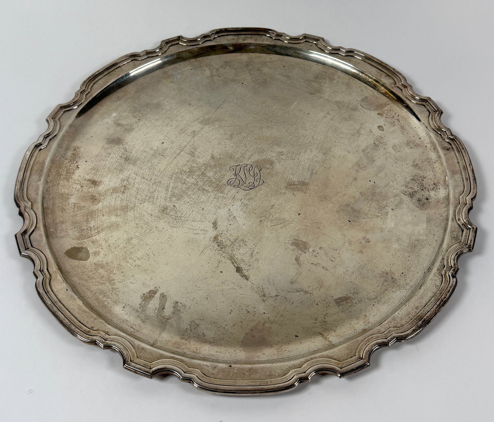 TIFFANY & CO. STERLING SILVER TRAY: LARGE TIFFANY & CO. STERLING SILVER SERVING TRAY, SCALLOPED EDGE, MARKED, STERLING SILVER, MONOGRAMMED. 1,548 GRAMS IN TOTAL WEIGHT, 16" DIA.