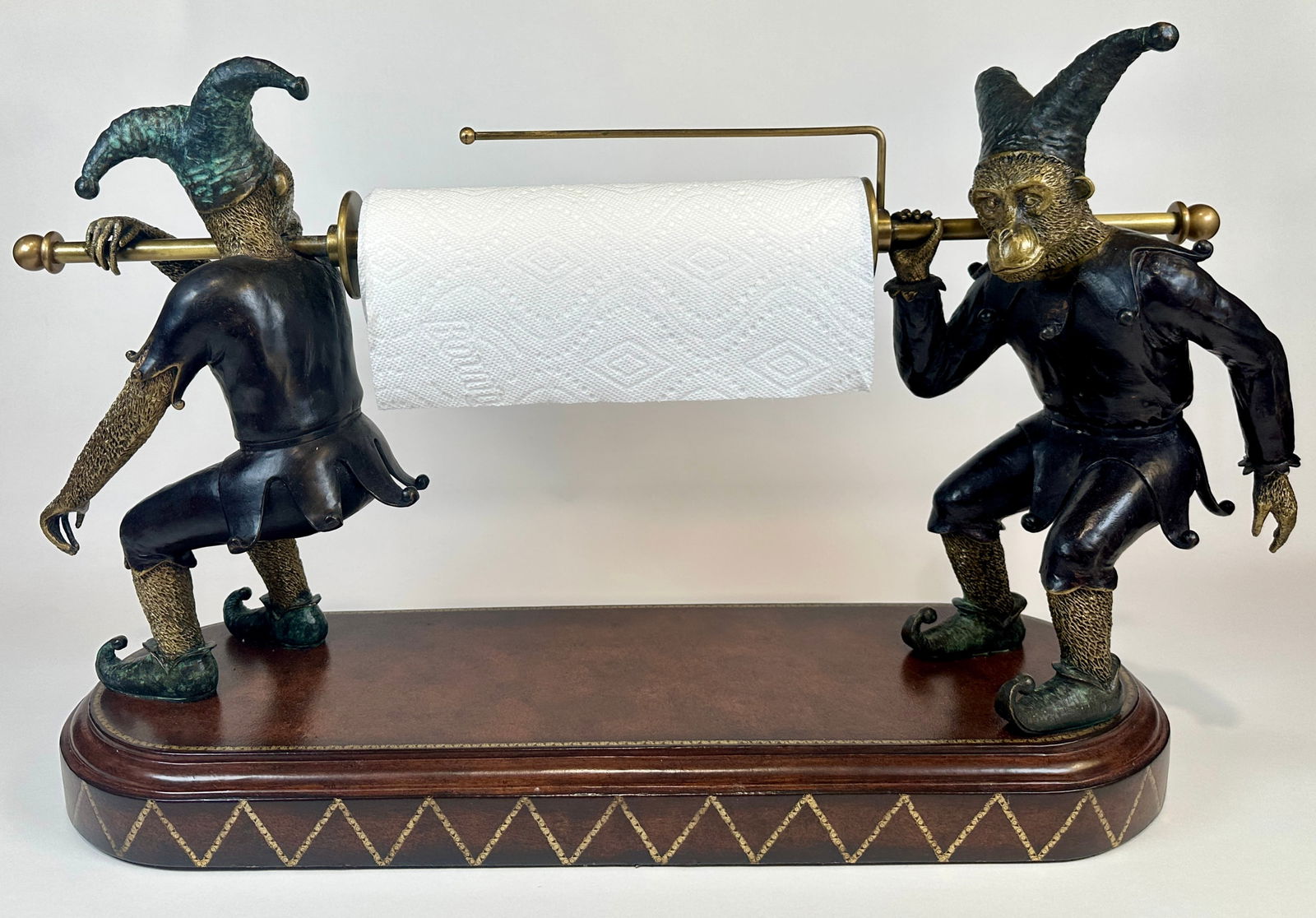 MAITLAND SMITH GILT MONEKY TOWEL HOLDER: PAIR OF MONKEYS HOLDING A PAPER TOWEL ROD, LEATHER BASE. LABELED. 17.5"H, 26"W, 9.5"W. APPROX. 35 POUNDS.