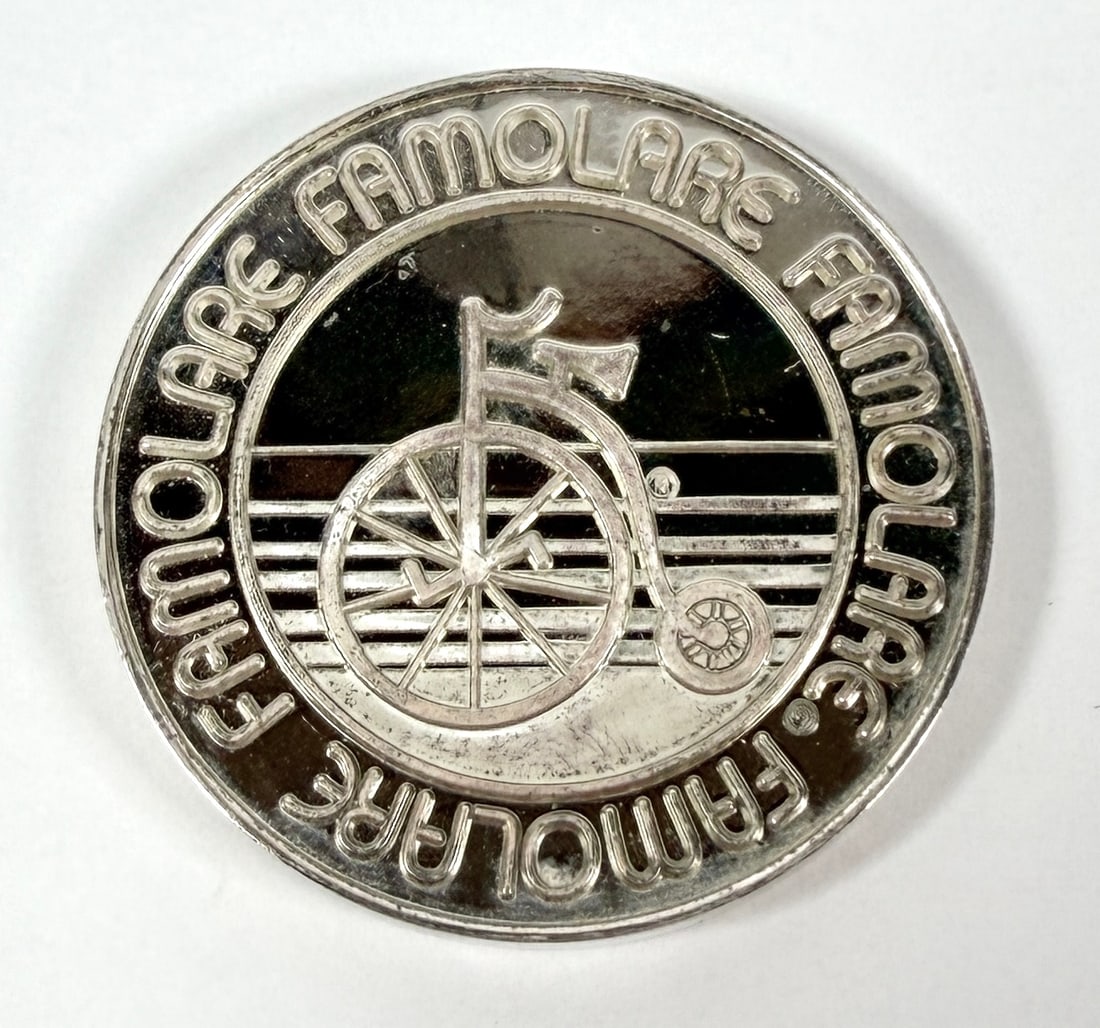 FAMOLARE SILVER ART ROUND: FAMOLARE WAS A POPULAR SHOE BRAND IN THE 1970.S SILVER COIN WITH BRAND AND PENNY FARTHING BICYCLE. 999 FINE SILVER, 69 GRAMS IN TOTAL WEIGHT