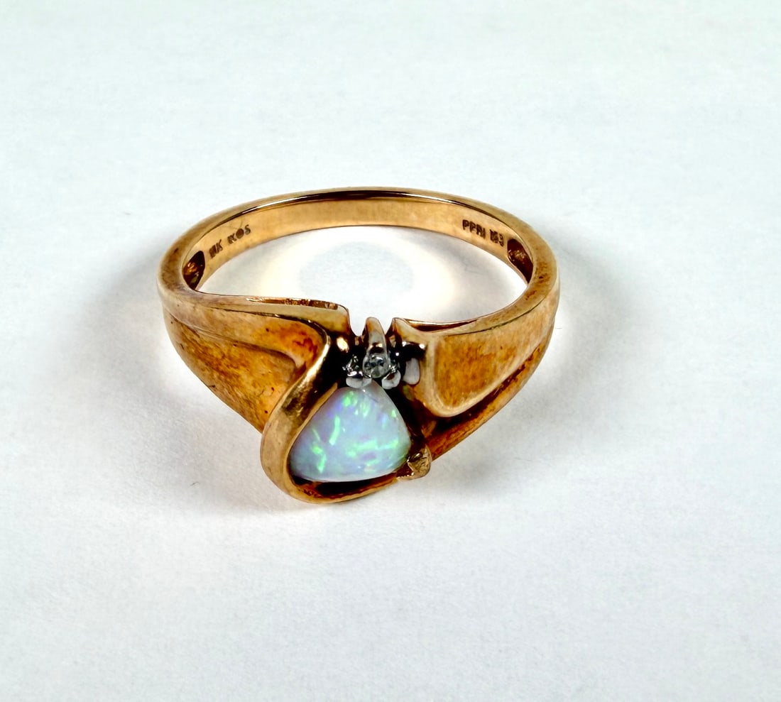 10K GOLD WITH OPAL LADIES RING: 10K GOLD WITH OPAL AND DIAMOND ACCENT. 2.9 GRAMS. SIZE 6.75