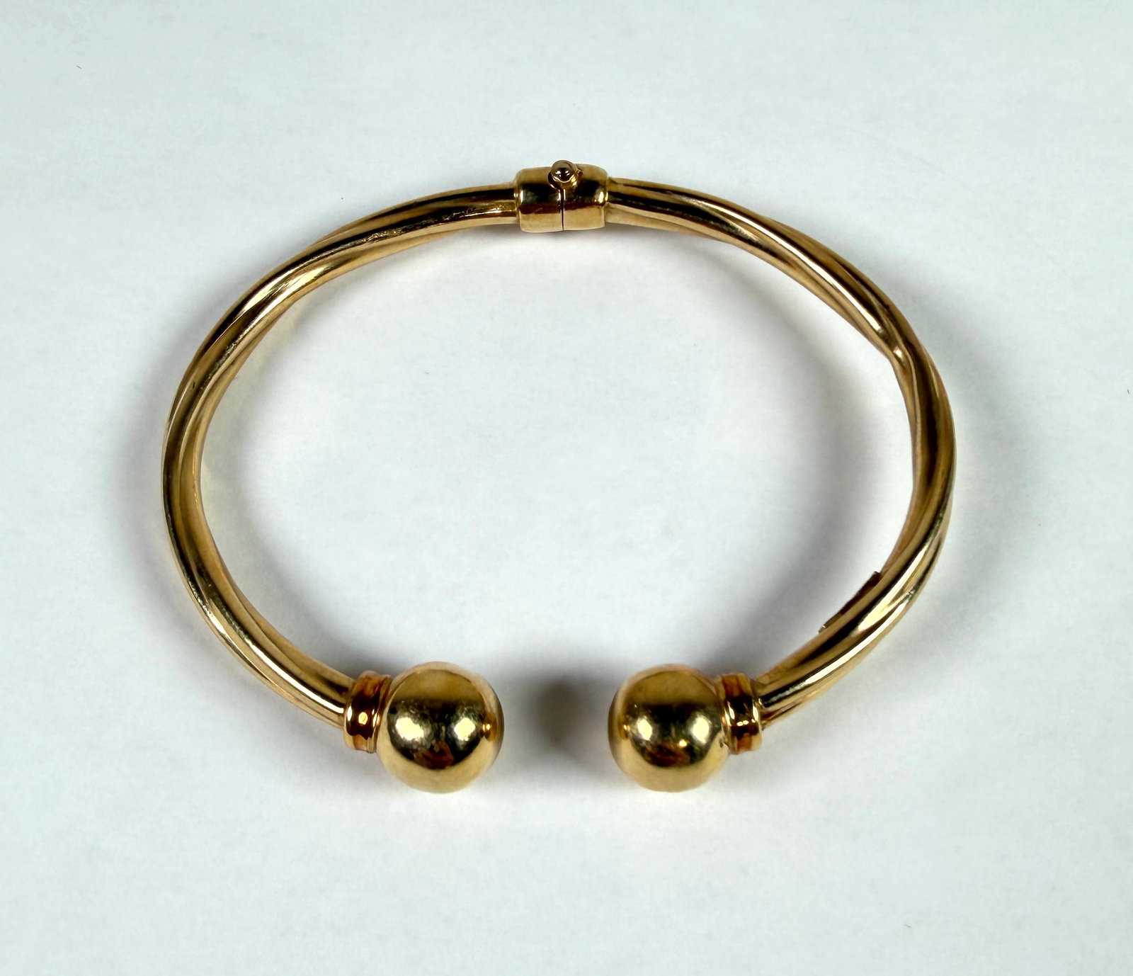 14K GOLD BRACELET: BALL ACCENTS, HINGED. HAS A DING IN ONE OF THE BALLS. 3.5". 10.6 GRAMS.