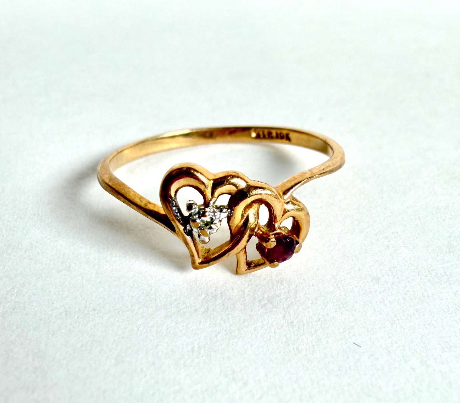 10K GOLD LADIES HEART RING: DOUBLE HEART DESIGN WITH CZ/RUBY. 1.1 GRAMS. SIZE 6.5.
