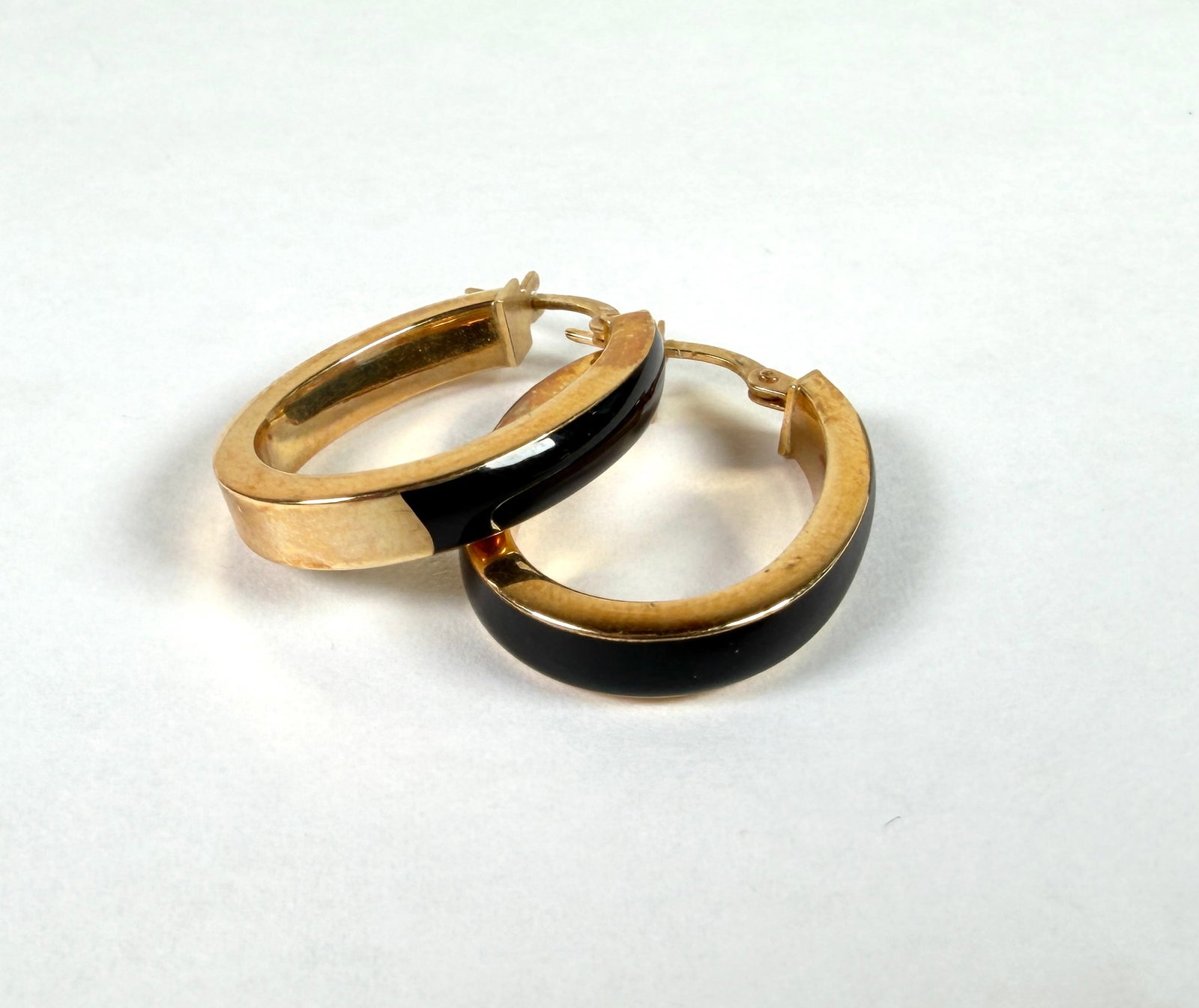 14K GOLD ONYX HOOP EARRINGS: OVAL HOOPS WITH ONYX ACCENTS. 3.1 GRAMS IN TOTAL WEIGHT. 1"X.75"