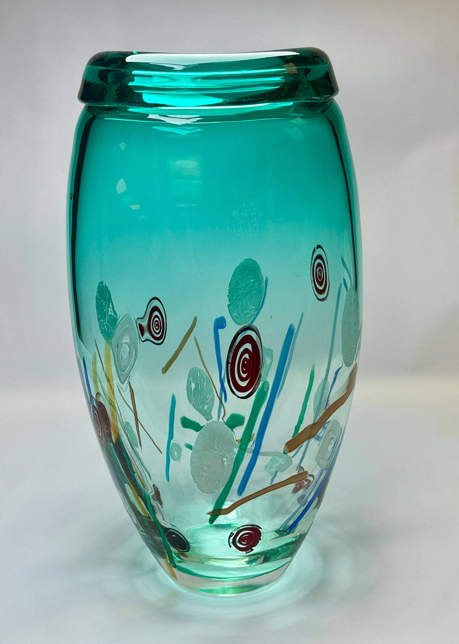 SILVANO SIGNORETTO MONUMENTAL MURANO ART GLASS VASE: SIGNED S. SIGNORETTO. MONUMENTAL ART GLASS VASE WITH RADIANT TEAL COLOR, MURRINE AND CANE DESIGN. 18.5". CONDITION REPORT AVAILABLE ON REQUEST. CANNOT ISSUE REPORTS WHILE AUCTION IS IN PROGRESS.