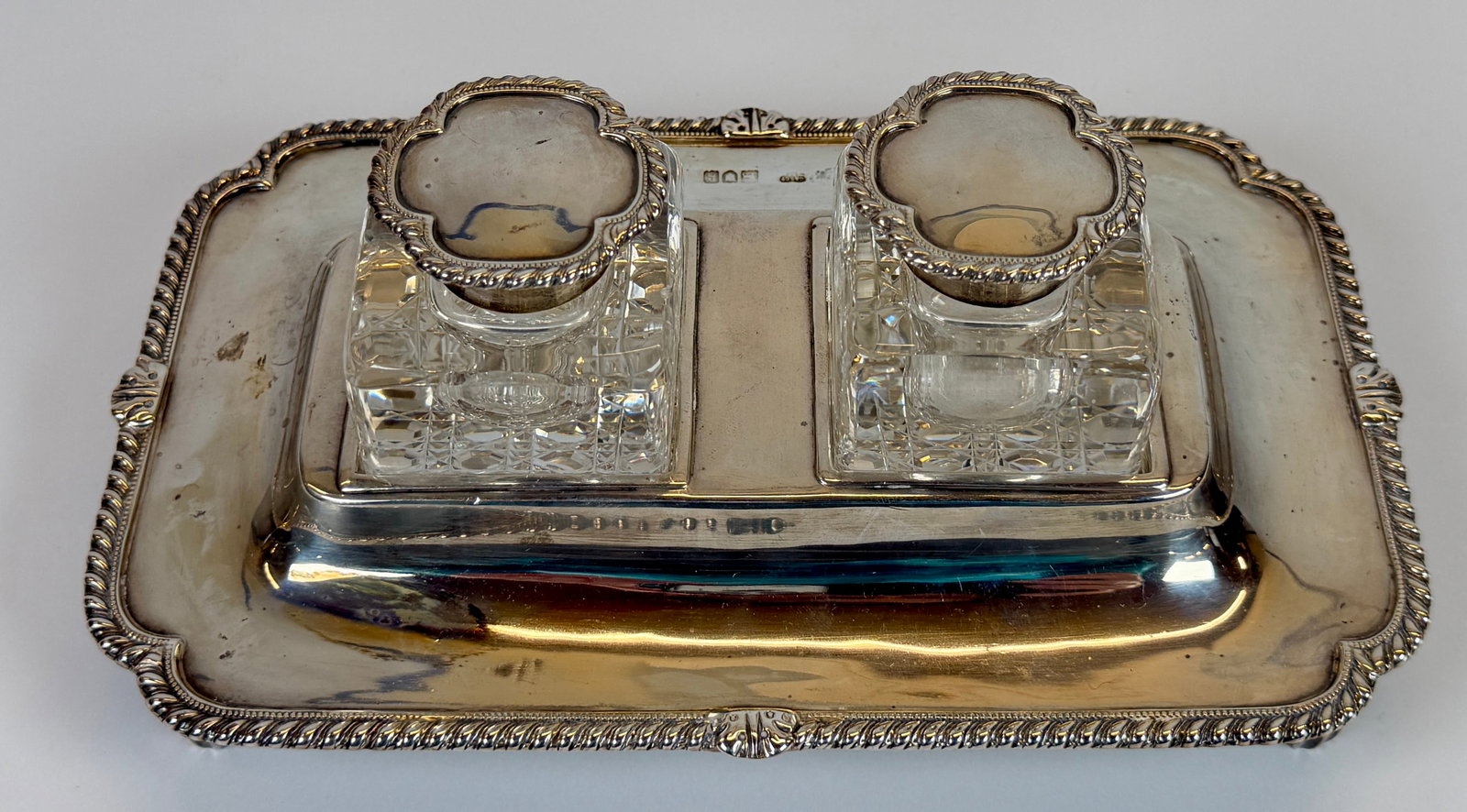 STERLING SILVER MOUNTED INKWELLS: GOLDSMITHS AND SILVERSMITHS CO. LTD. HALLMARKED. STERLING SILVER BASE IS 398 GRAMS TOTAL WEIGHT. STERLING SILVER FITTED INKWELLS WITH HINGED LIDS.