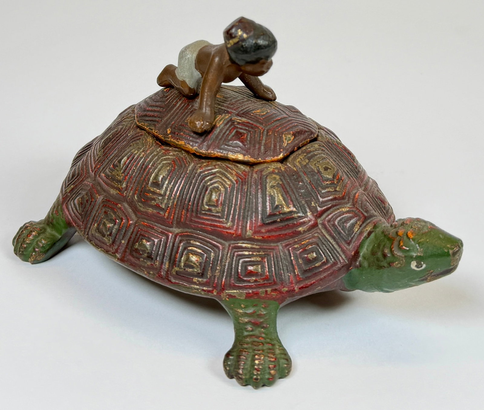 CAST IRON FIGURAL INKWELL: PAINTED CAST IRON INKWELL, BOY RIDING TURTLE. MARKED 328 ON VERSO. 5.5"H