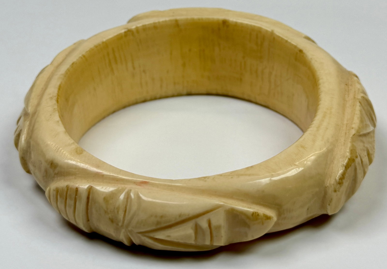 BONE CARVED TRIBAL BRACELET: GRADUATED CARVINGS OF MASKS. 137 GRAMS TOTAL WEIGHT.