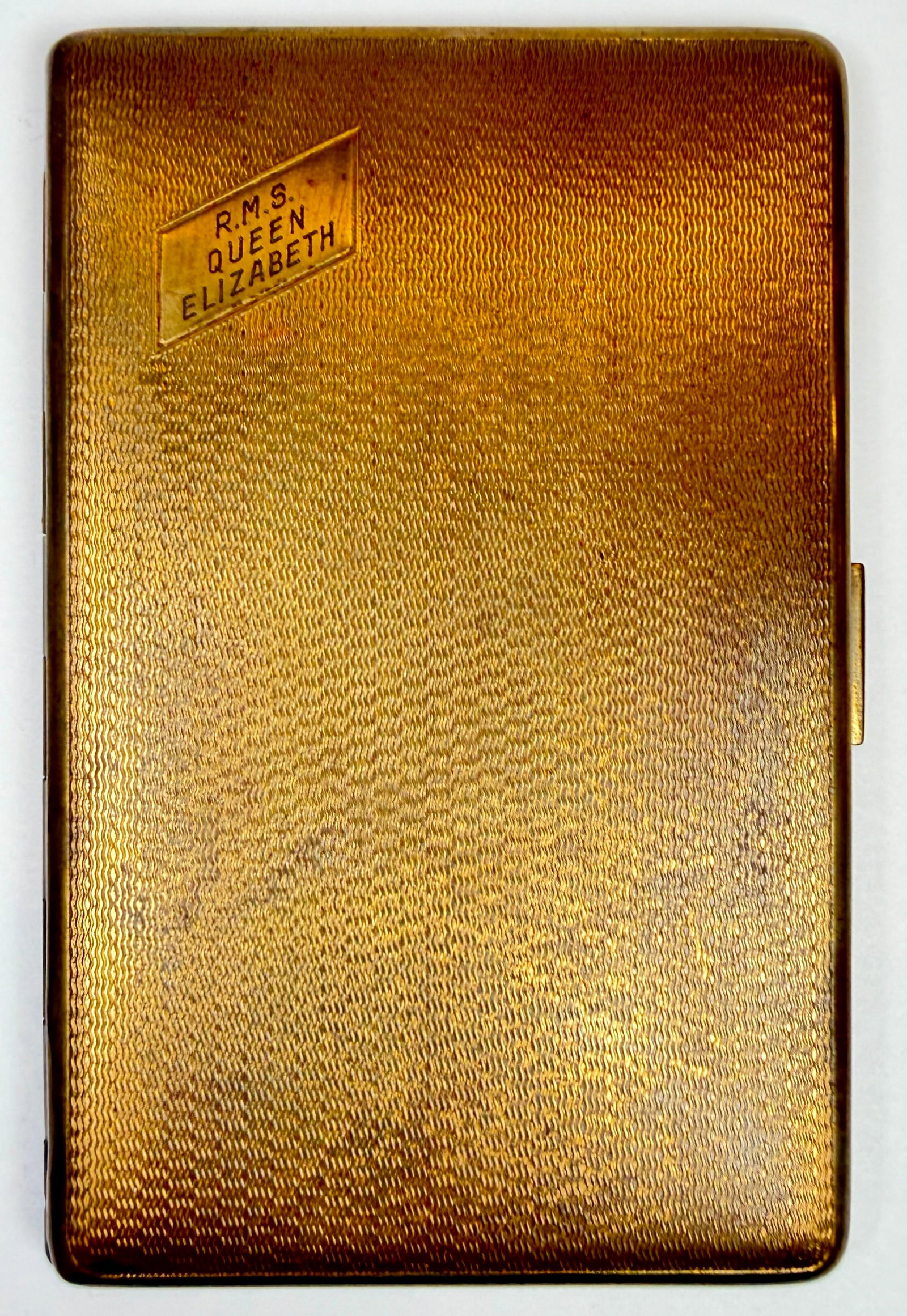 HAR-BRO R.M.S. QUEEN ELIZABETH CIGARETTE CASE: GOLD-TONED CASE, MARKED. 3.5"X5.5"