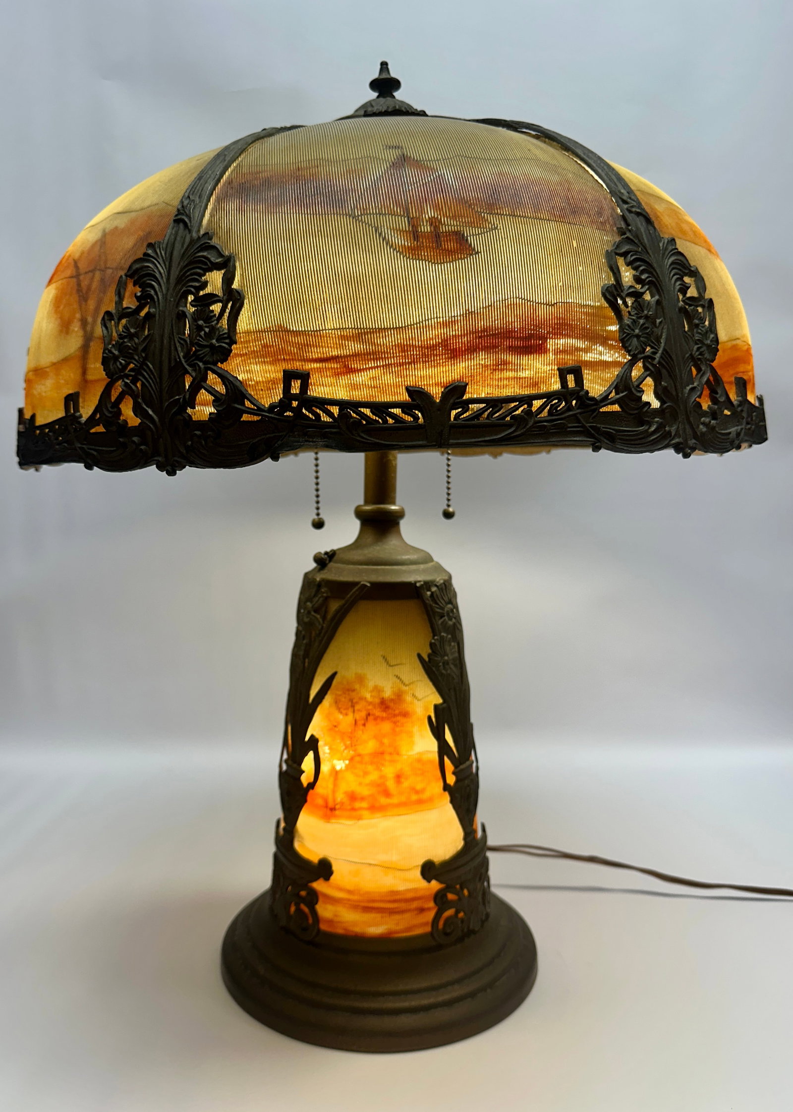 ANTIQUE JEFFERSON STYLE PANEL LAMP: SIX PANEL SHADE WITH OUTDOOR LANDSCAPE MOTIF. RIBBED GLASS INSERTS IN SHADE AND BASE. REQUIRES THIRD PARTY SHIPPING. 25"H