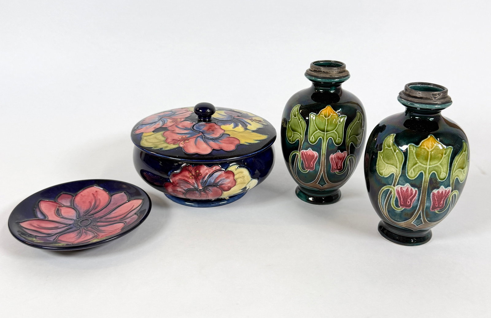 MOORCROFT POTTERY GROUPING: COVERED JAR, METAL FITTED BOTTLES, ROUND DISH. MARKED.