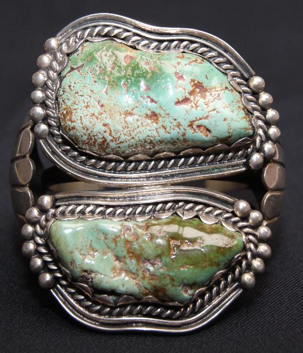 Navajo Bracelet: 1960s 70s sterling silver and two large turquoise stones 5.25" x 3" x 1.25" opening Shipping charge on this item is $10.00. Unless noted all items have some